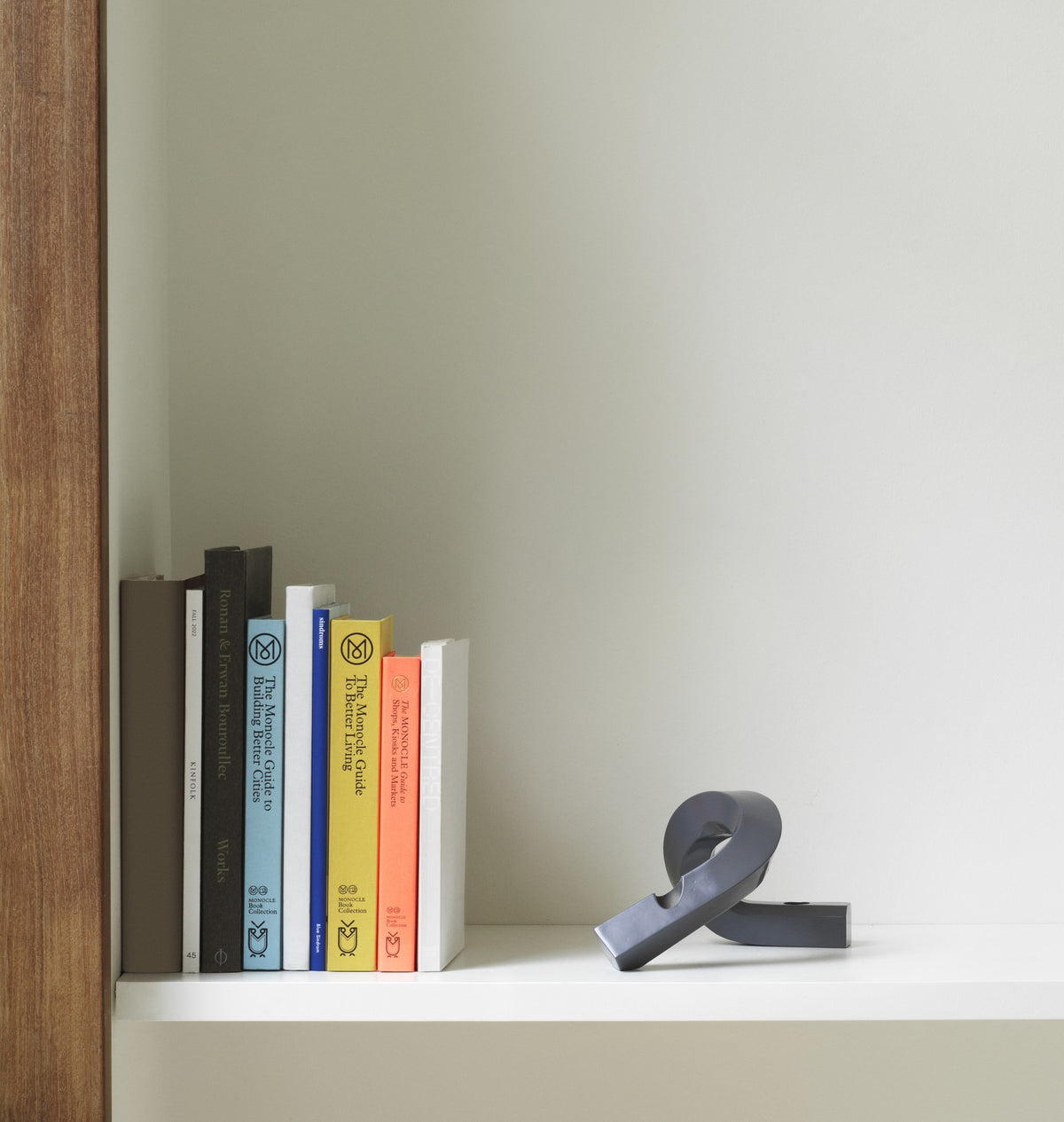 Kerzenhalter Crooked von Normann Copenhagen aus lackiertem Aluminium in Warmes Grau mit geschwungener, skulpturaler Form.