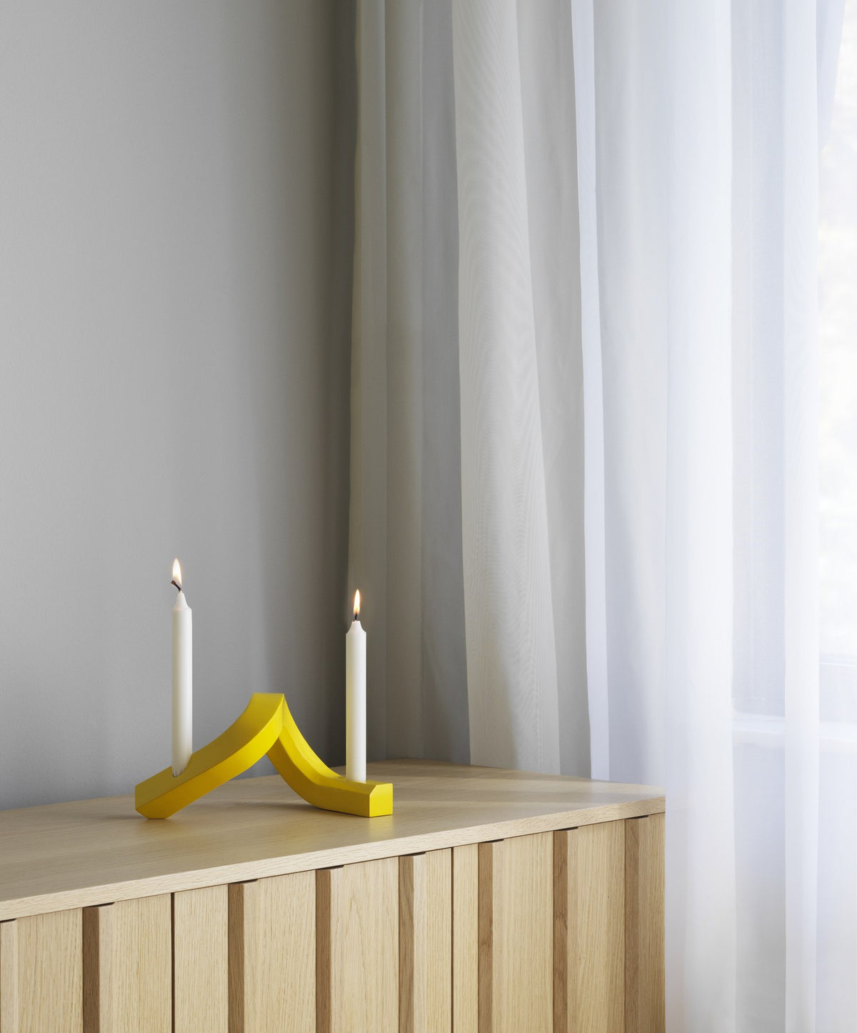 Kerzenhalter Crooked von Normann Copenhagen aus lackiertem Aluminium in Warmes Grau mit geschwungener, skulpturaler Form.