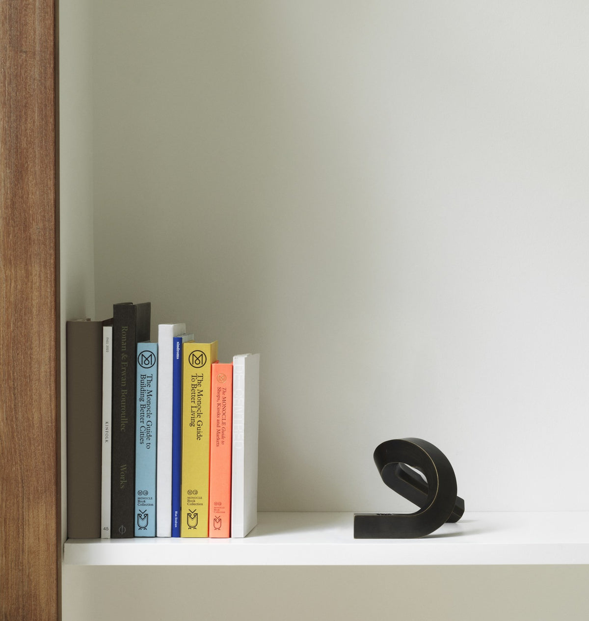Kerzenhalter Crooked von Normann Copenhagen aus lackiertem Aluminium in Warmes Grau mit geschwungener, skulpturaler Form.