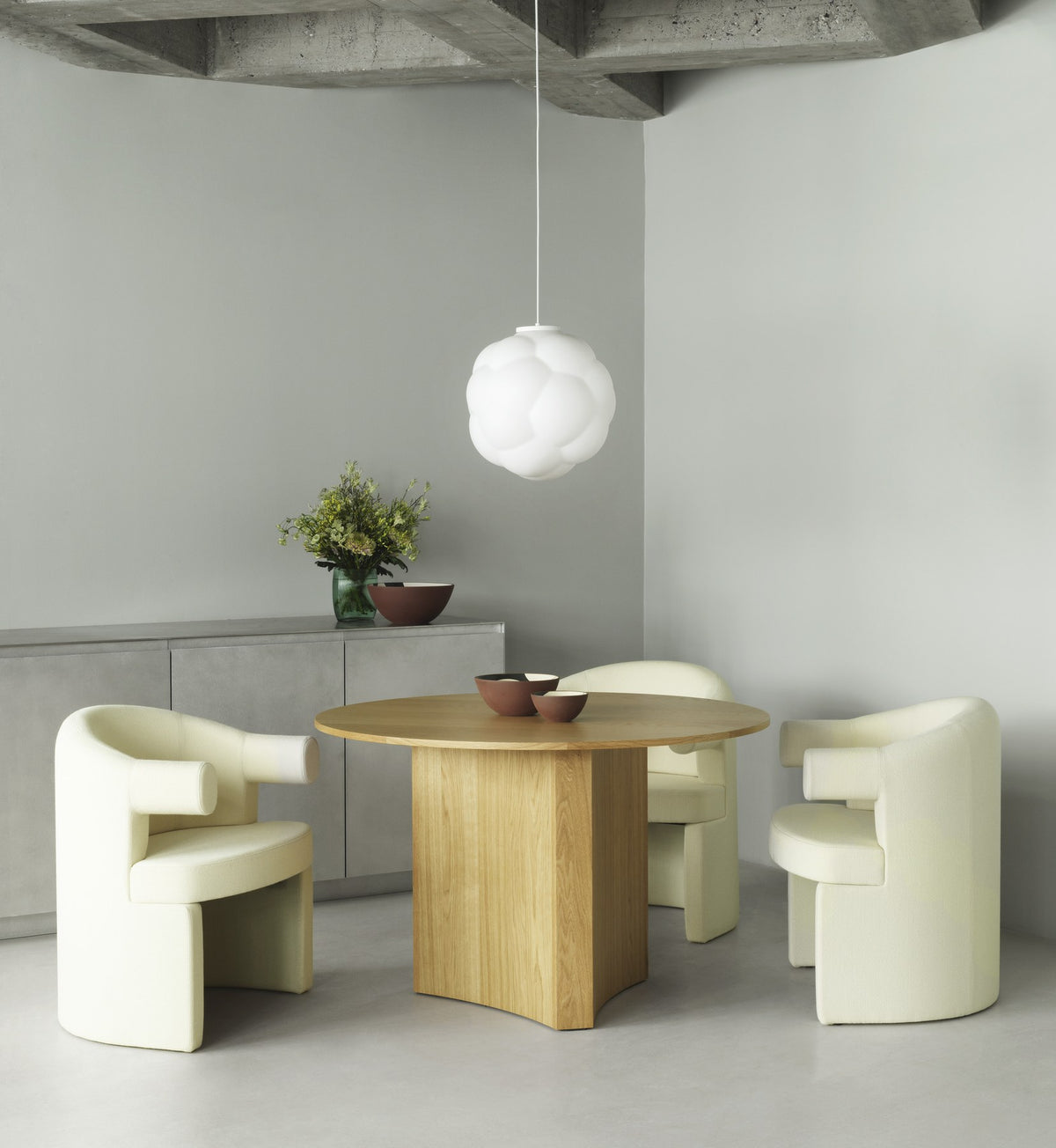 Burra Stuhl von Normann Copenhagen in Olivgrün: gepolsterter Sitz mit runder Form, geschwungener Rückenlehne und integrierten Armlehnen.