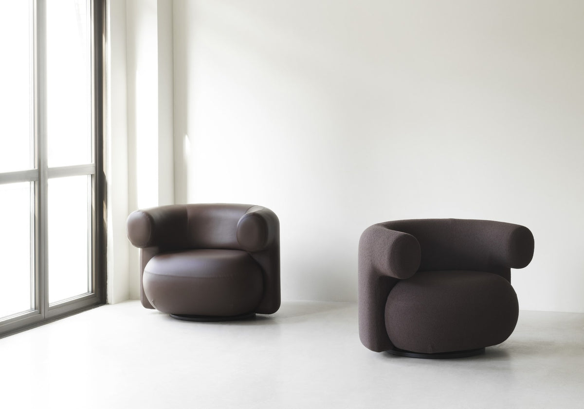 Grauer Burra Lounge-Sessel von Normann Copenhagen mit rundem, gepolstertem Sitz, geschwungener Rückenlehne und Drehfuss aus Holz.