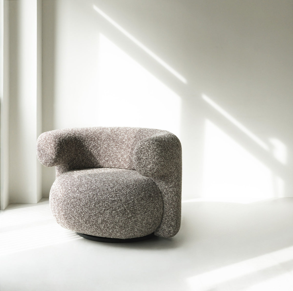 Grauer Burra Lounge-Sessel von Normann Copenhagen mit rundem, gepolstertem Sitz, geschwungener Rückenlehne und Drehfuss aus Holz.