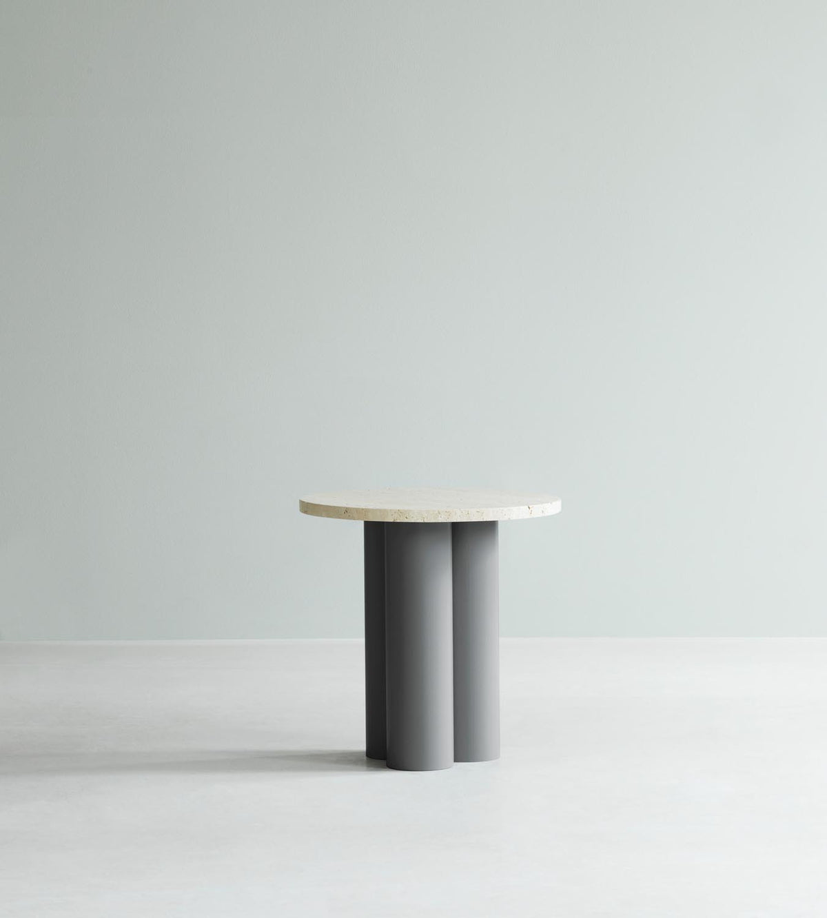 Beistelltisch Dit von Normann Copenhagen mit runder Tischplatte aus Stein in Sand Travertine Light, getragen von drei zylindrischen Stahlbeinen.