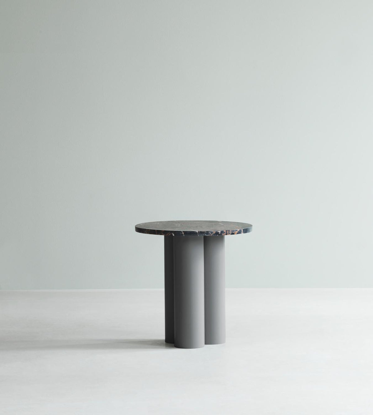 Beistelltisch Dit von Normann Copenhagen mit runder Tischplatte aus Stein in Sand Travertine Light, getragen von drei zylindrischen Stahlbeinen.