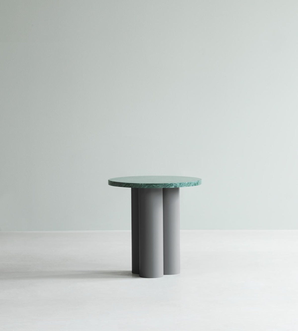 Beistelltisch Dit von Normann Copenhagen mit runder Tischplatte aus Stein in Sand Travertine Light, getragen von drei zylindrischen Stahlbeinen.