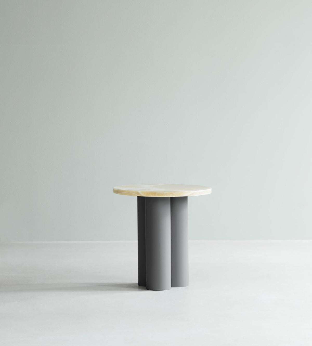 Beistelltisch Dit von Normann Copenhagen mit runder Tischplatte aus Stein in Sand Travertine Light, getragen von drei zylindrischen Stahlbeinen.