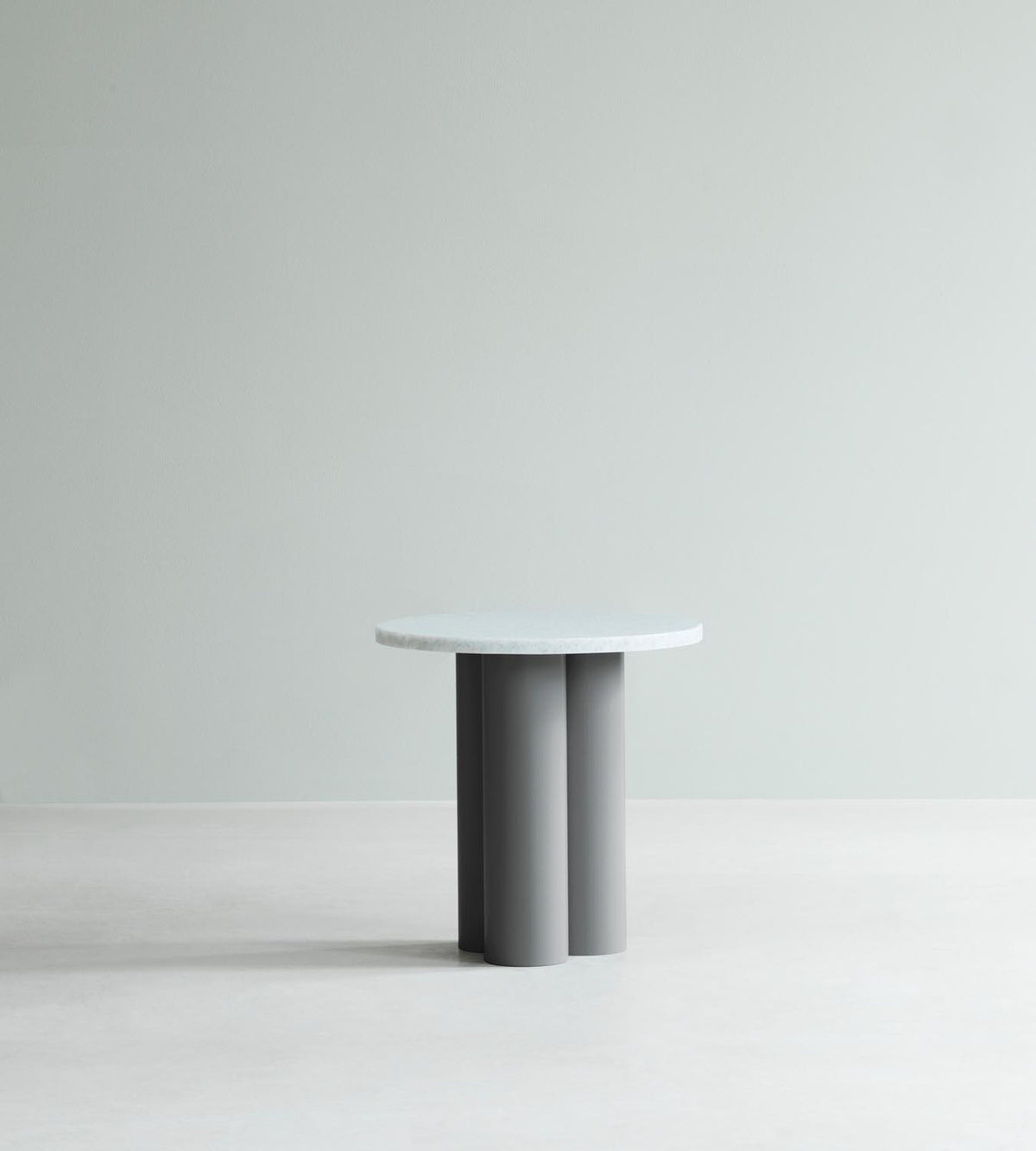 Beistelltisch Dit von Normann Copenhagen mit runder Tischplatte aus Stein in Sand Travertine Light, getragen von drei zylindrischen Stahlbeinen.
