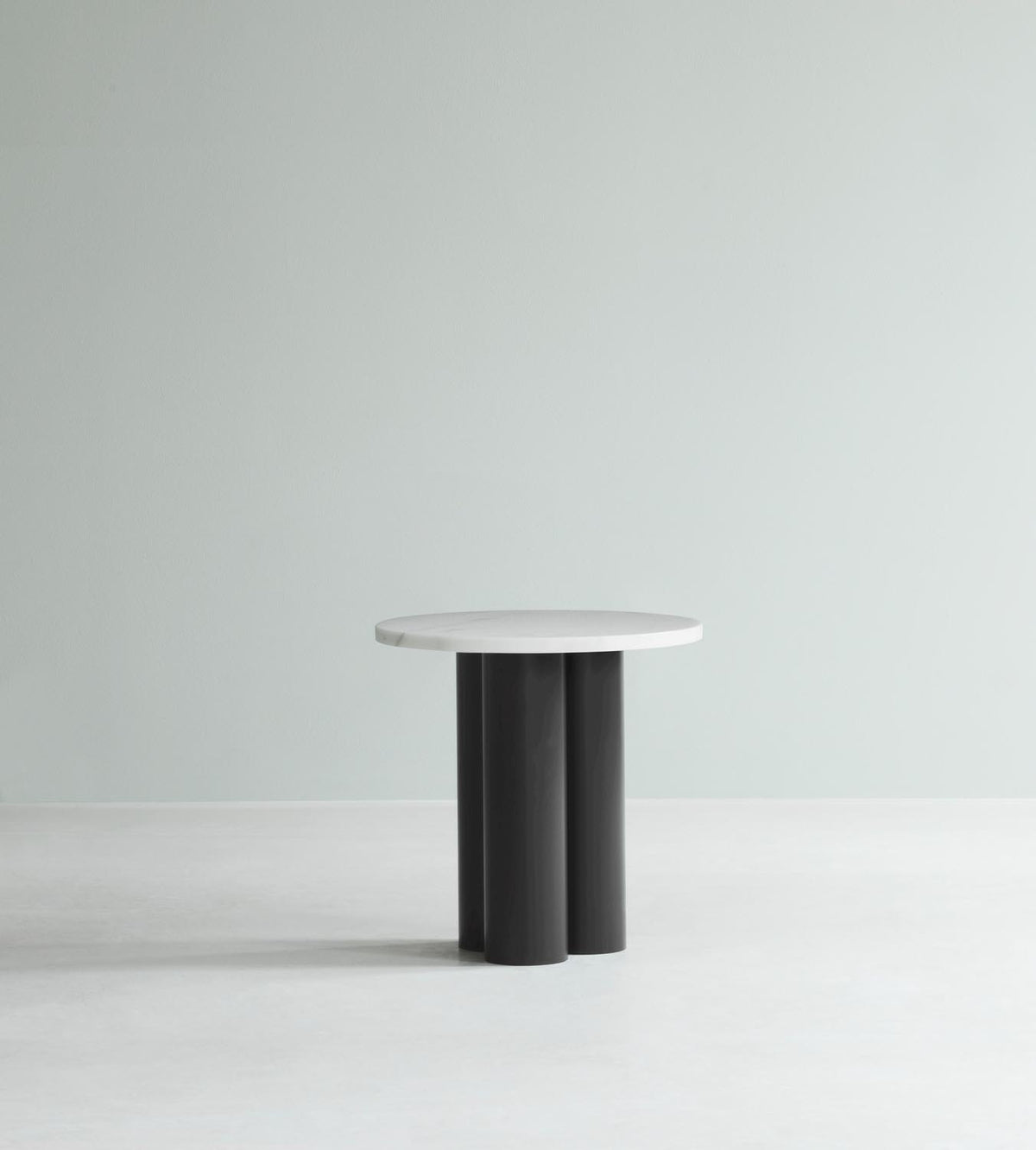 Beistelltisch Dit von Normann Copenhagen mit runder Tischplatte aus Stein in Sand Travertine Light, getragen von drei zylindrischen Stahlbeinen.