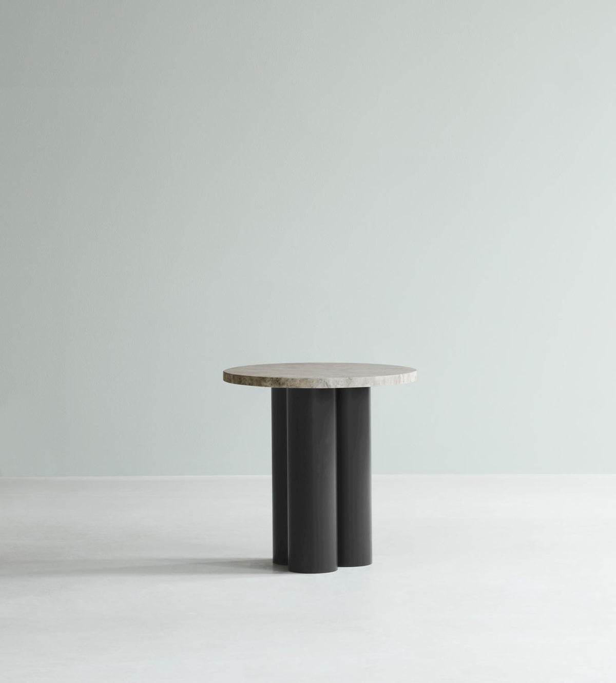 Beistelltisch Dit von Normann Copenhagen mit runder Tischplatte aus Stein in Sand Travertine Light, getragen von drei zylindrischen Stahlbeinen.