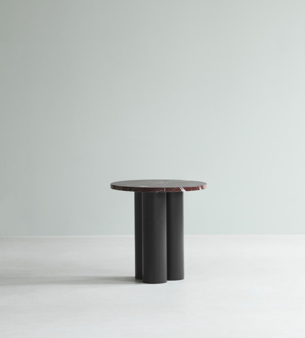 Beistelltisch Dit von Normann Copenhagen mit runder Tischplatte aus Stein in Sand Travertine Light, getragen von drei zylindrischen Stahlbeinen.
