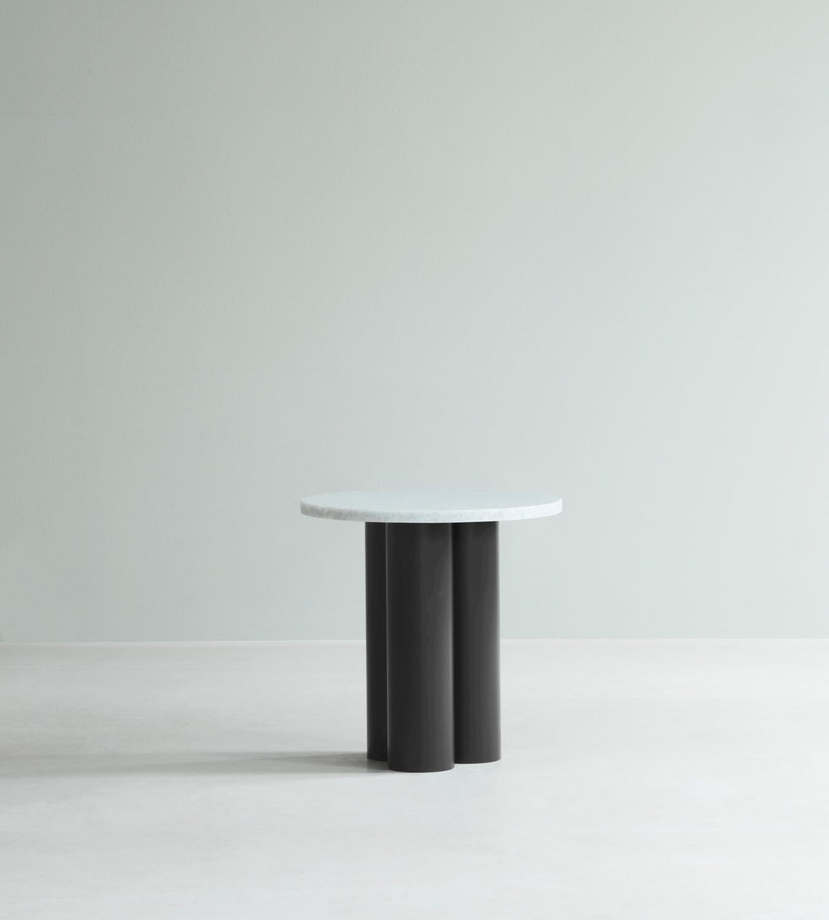 Beistelltisch Dit von Normann Copenhagen mit runder Tischplatte aus Stein in Sand Travertine Light, getragen von drei zylindrischen Stahlbeinen.