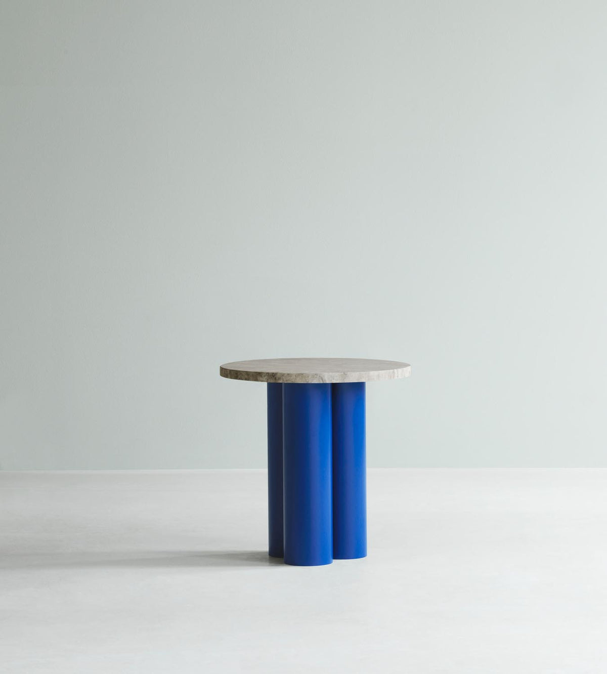 Beistelltisch Dit von Normann Copenhagen mit runder Tischplatte aus Stein in Sand Travertine Light, getragen von drei zylindrischen Stahlbeinen.