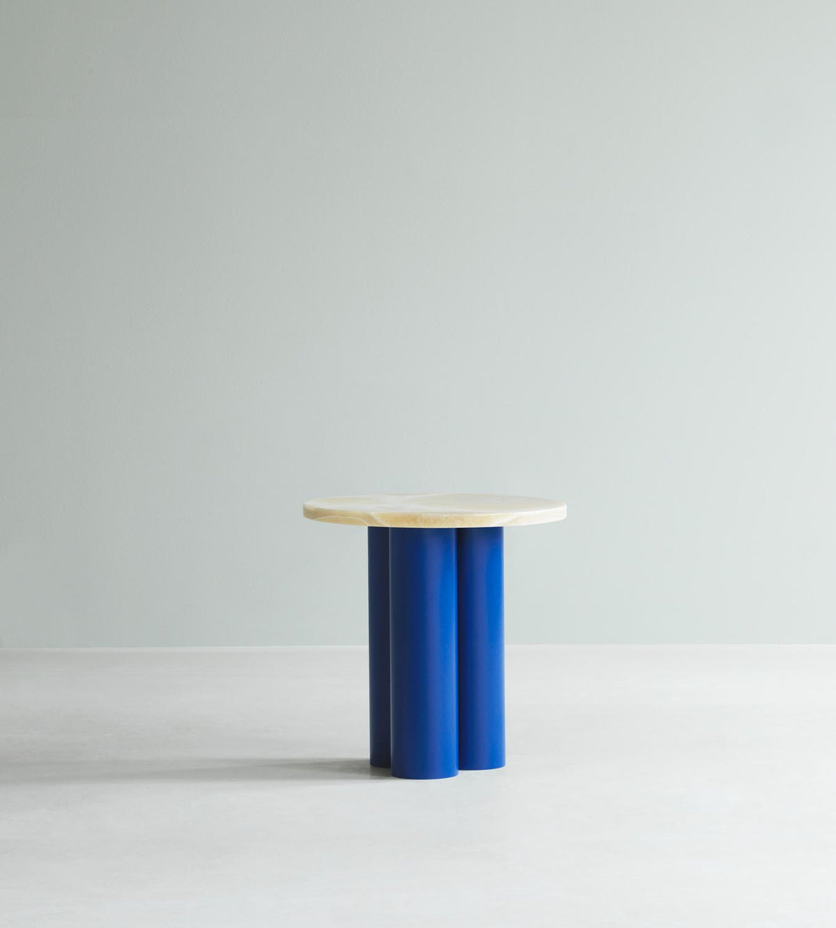 Beistelltisch Dit von Normann Copenhagen mit runder Tischplatte aus Stein in Sand Travertine Light, getragen von drei zylindrischen Stahlbeinen.