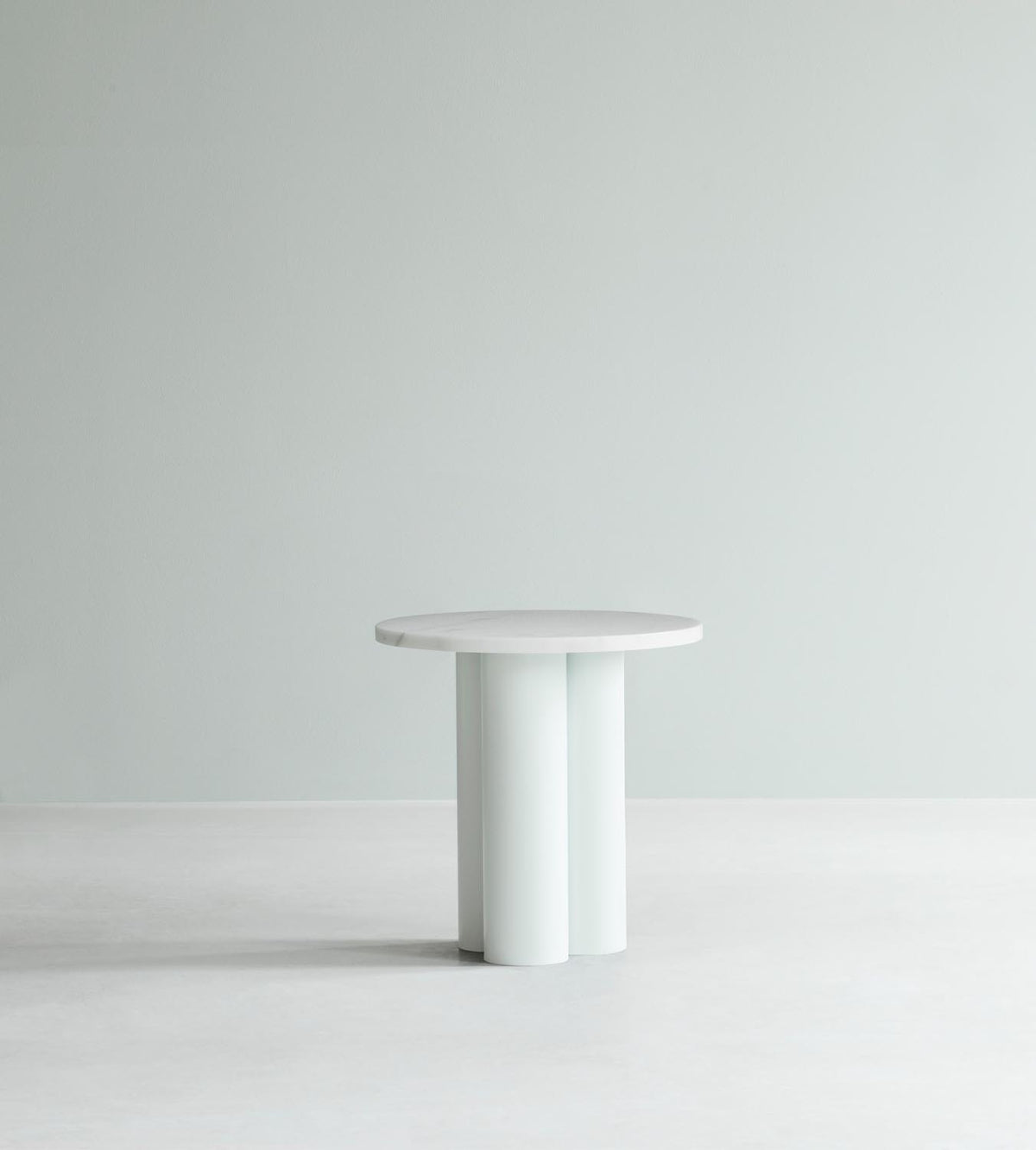 Beistelltisch Dit von Normann Copenhagen mit runder Tischplatte aus Stein in Sand Travertine Light, getragen von drei zylindrischen Stahlbeinen.