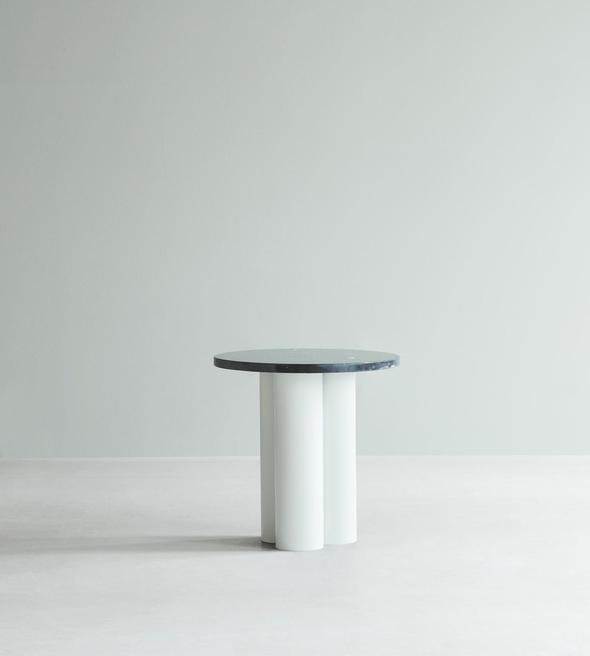 Beistelltisch Dit von Normann Copenhagen mit runder Tischplatte aus Stein in Sand Travertine Light, getragen von drei zylindrischen Stahlbeinen.