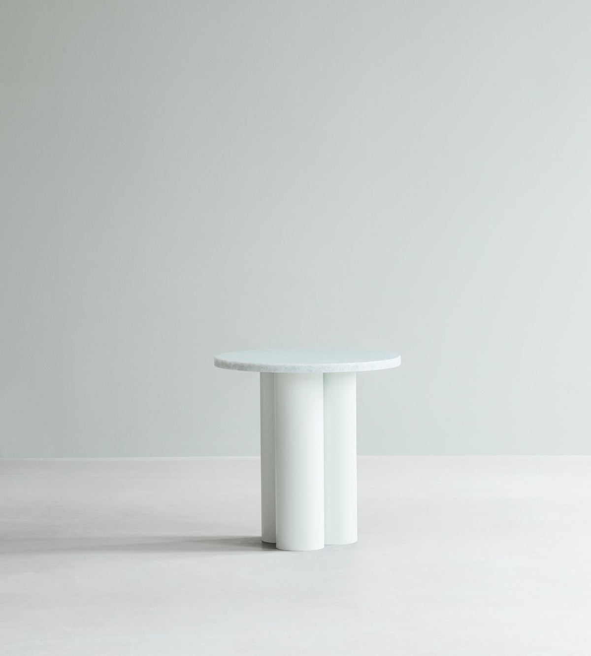 Beistelltisch Dit von Normann Copenhagen mit runder Tischplatte aus Stein in Sand Travertine Light, getragen von drei zylindrischen Stahlbeinen.