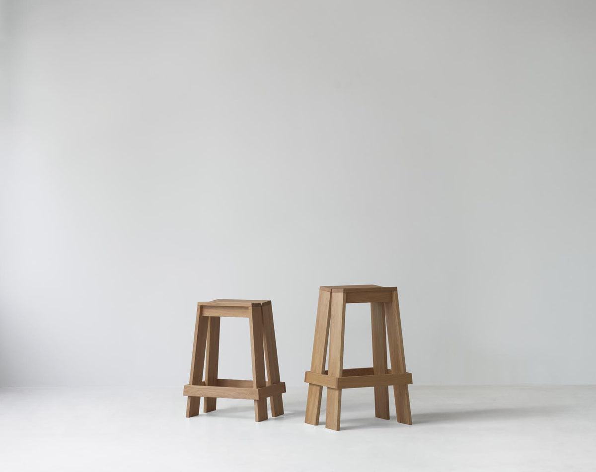 Barhocker Let 65 cm von Normann Copenhagen aus lackierter Eiche mit zwei parallelen, leicht geneigten Holzbrettern als Sitzfläche.