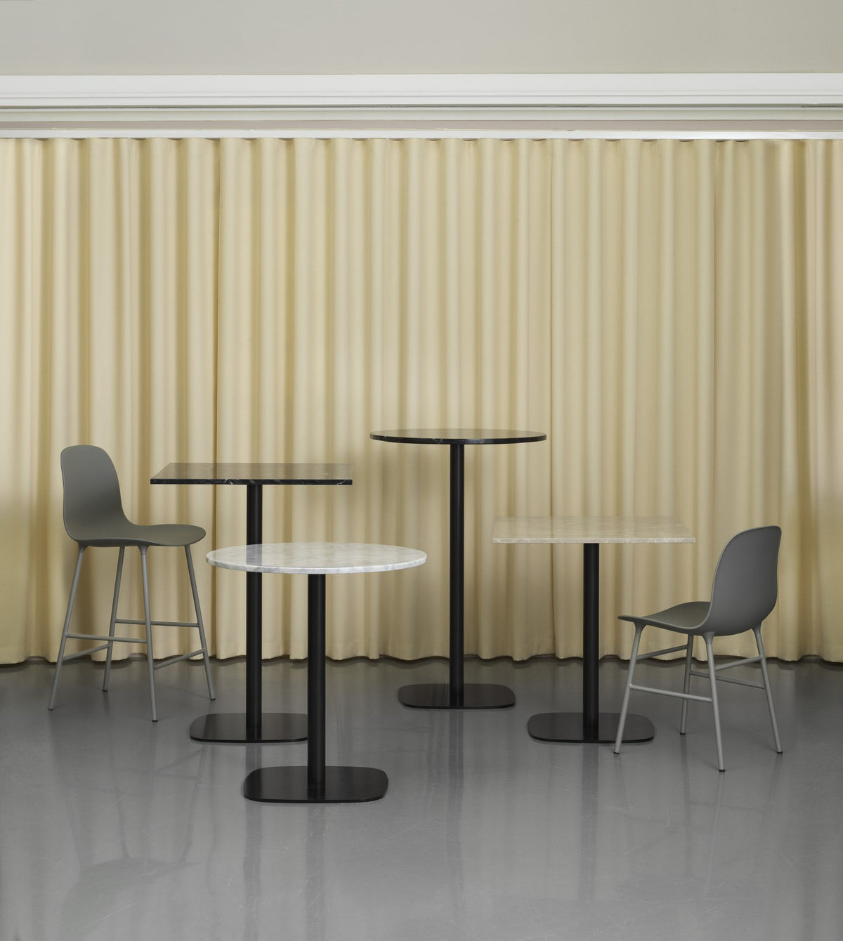 Runder Esstisch Form Café Table mit Tischplatte aus Eichenfurnier und zylinderförmiger Basis aus schwarz lackiertem Aluminium.