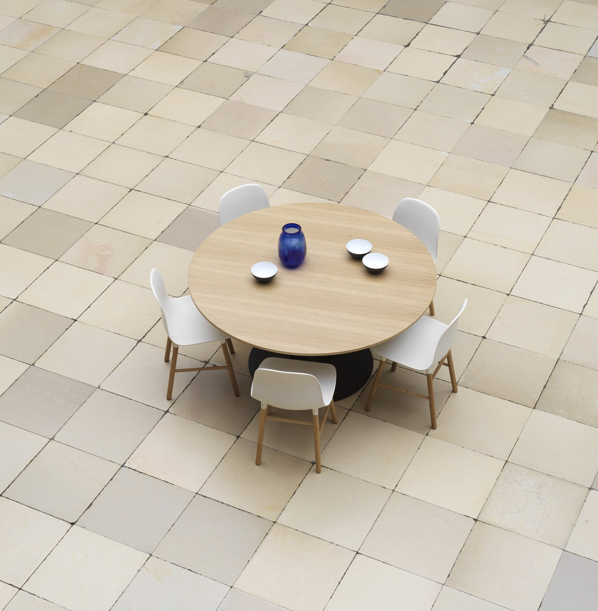 Runder Esstisch Scala von Normann Copenhagen mit Eiche-Furnier-Tischplatte und pulverbeschichtetem Stahlgestell aus vier Säulen, Ø130 cm.