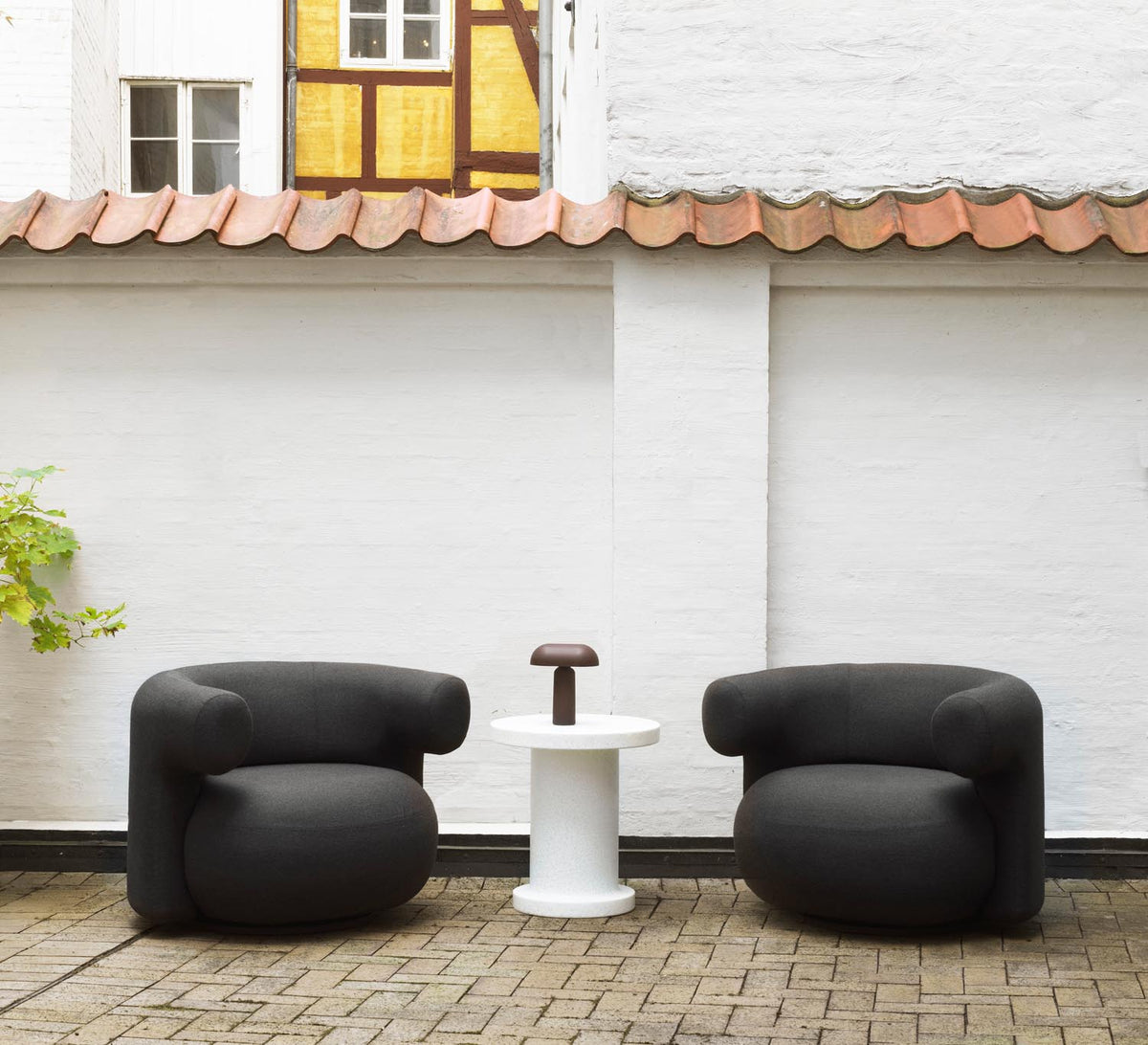 Drehsessel Burra Outdoor von Normann Copenhagen in Natté, Gestell aus Stahl und lackiertem Holz, runde skulpturale Sitzform.