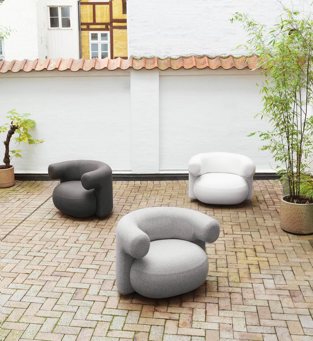 Drehsessel Burra Outdoor von Normann Copenhagen in Natté, Gestell aus Stahl und lackiertem Holz, runde skulpturale Sitzform.