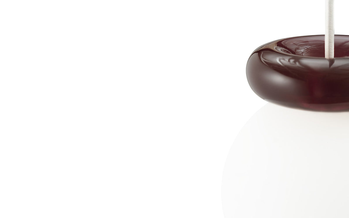 Pendelleuchte Hinx von Normann Copenhagen in Dunkelbraun, Lampenschirm aus Opalglas mit ringförmigem Kunstharzsockel.