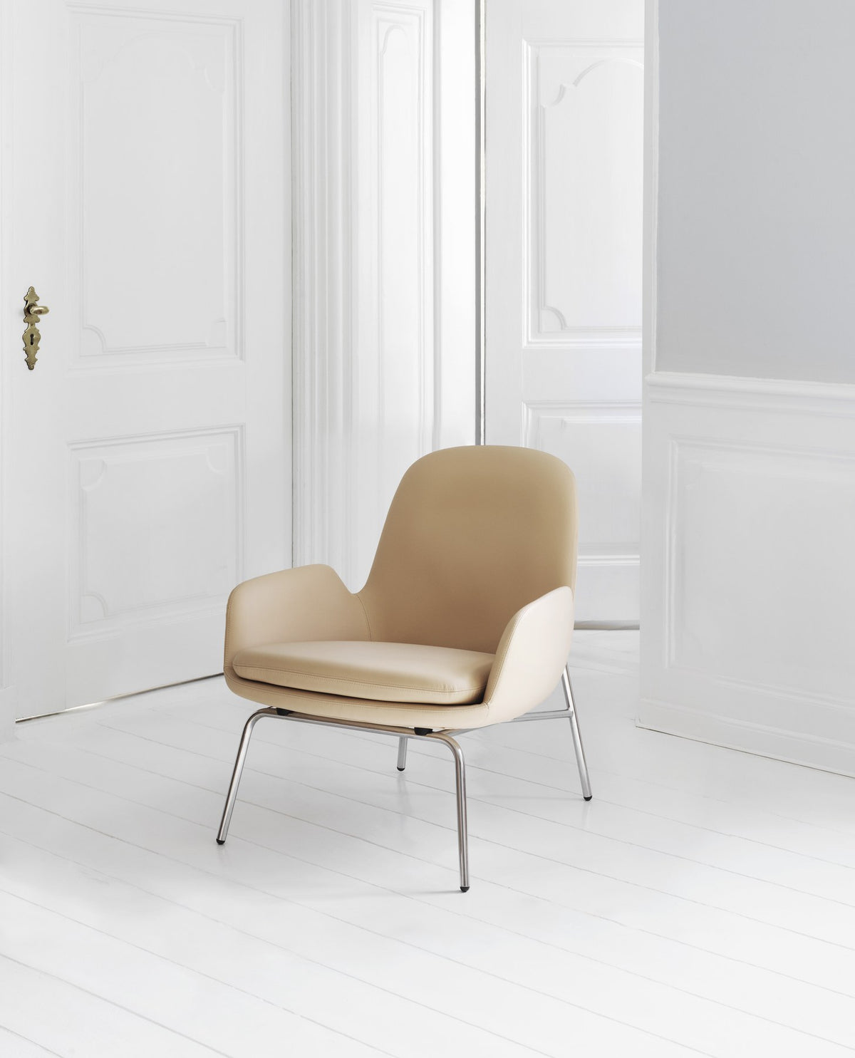 Era Lounge-Sessel in Beige mit verchromten Beinen, geschwungener Sitzschale und weich gepolstertem Kissen von Normann Copenhagen.