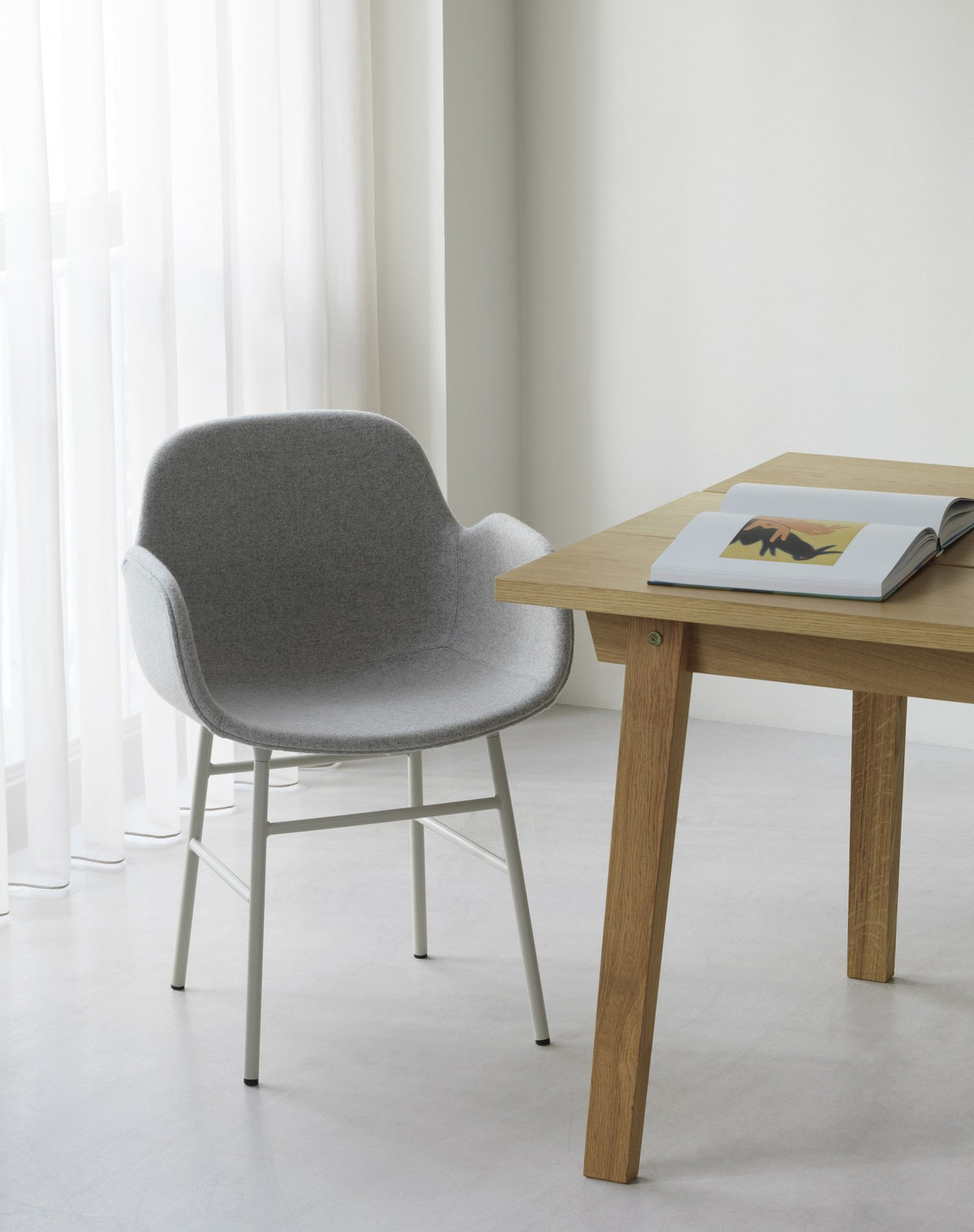 Form Lehnstuhl mit Armlehne von Normann Copenhagen, gepolsterte Sitzschale aus Polypropylen, Gestell aus schwarzem Stahl.