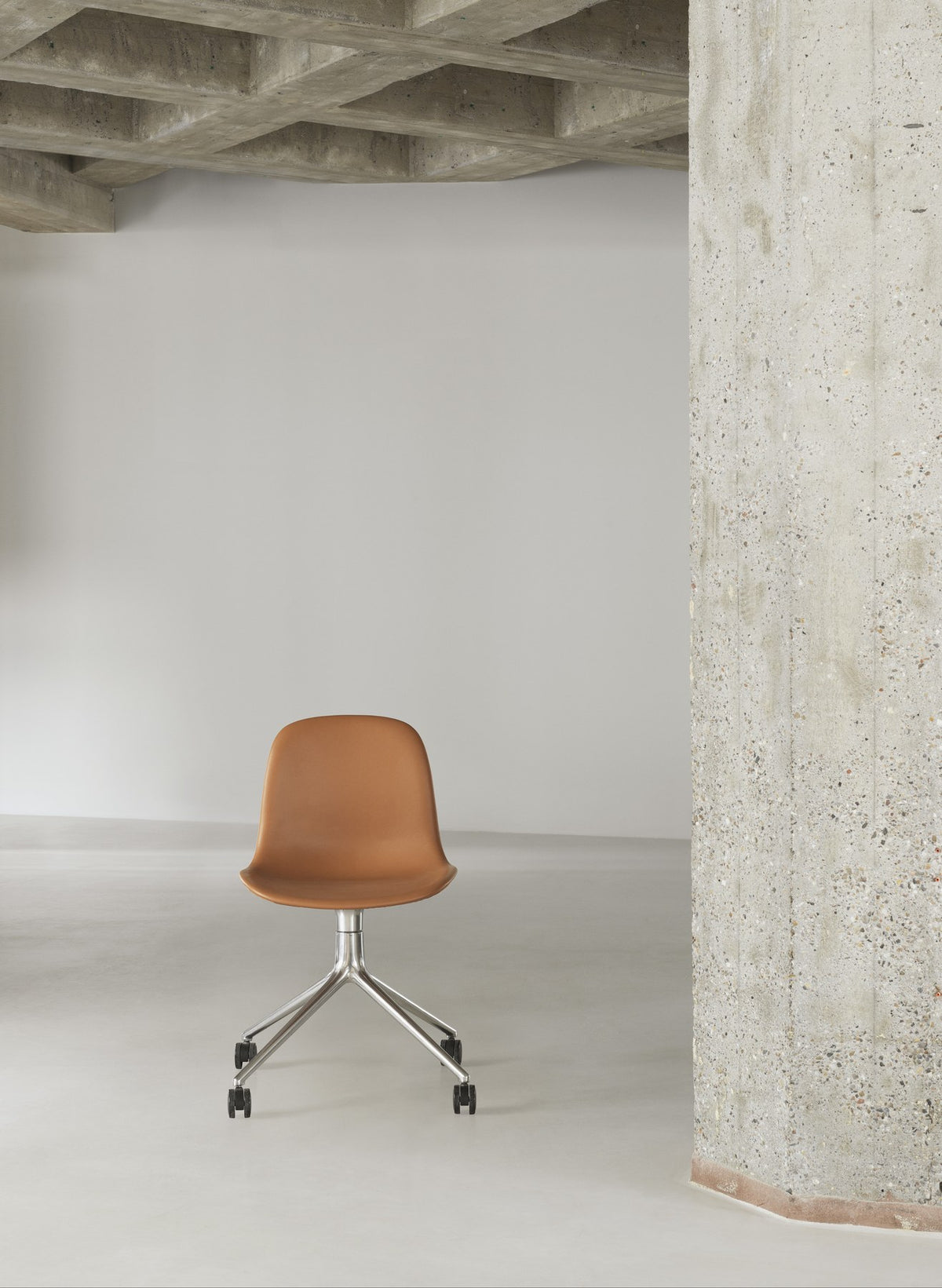 Form Drehstuhl von Normann Copenhagen mit brauner Polsterung, Sitzschale aus Polypropylen und Drehgestell aus Aluminium mit vier Rollen.