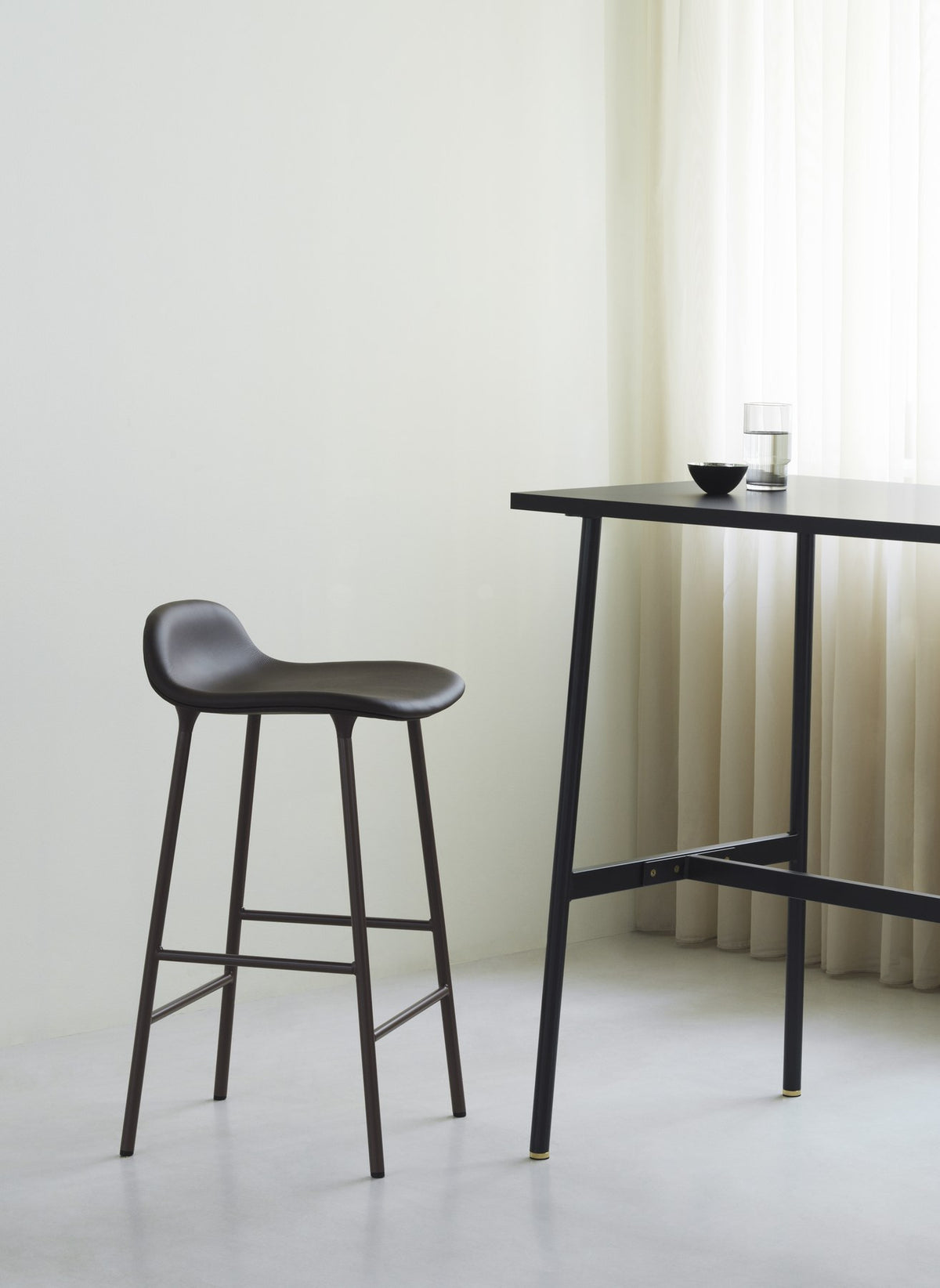 Grauer Barstuhl Form von Normann Copenhagen mit gepolsterter Sitzschale, Stahlbeinen und Sitzhöhe 65 cm.