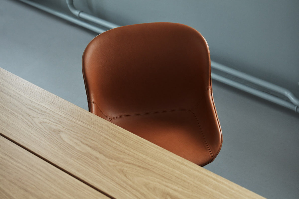 Hyg Comfort Stuhl von Normann Copenhagen in Braun, Vollpolster mit Aluminium-Drehgestell, gepolsterte Rückenlehne und Sitzfläche.