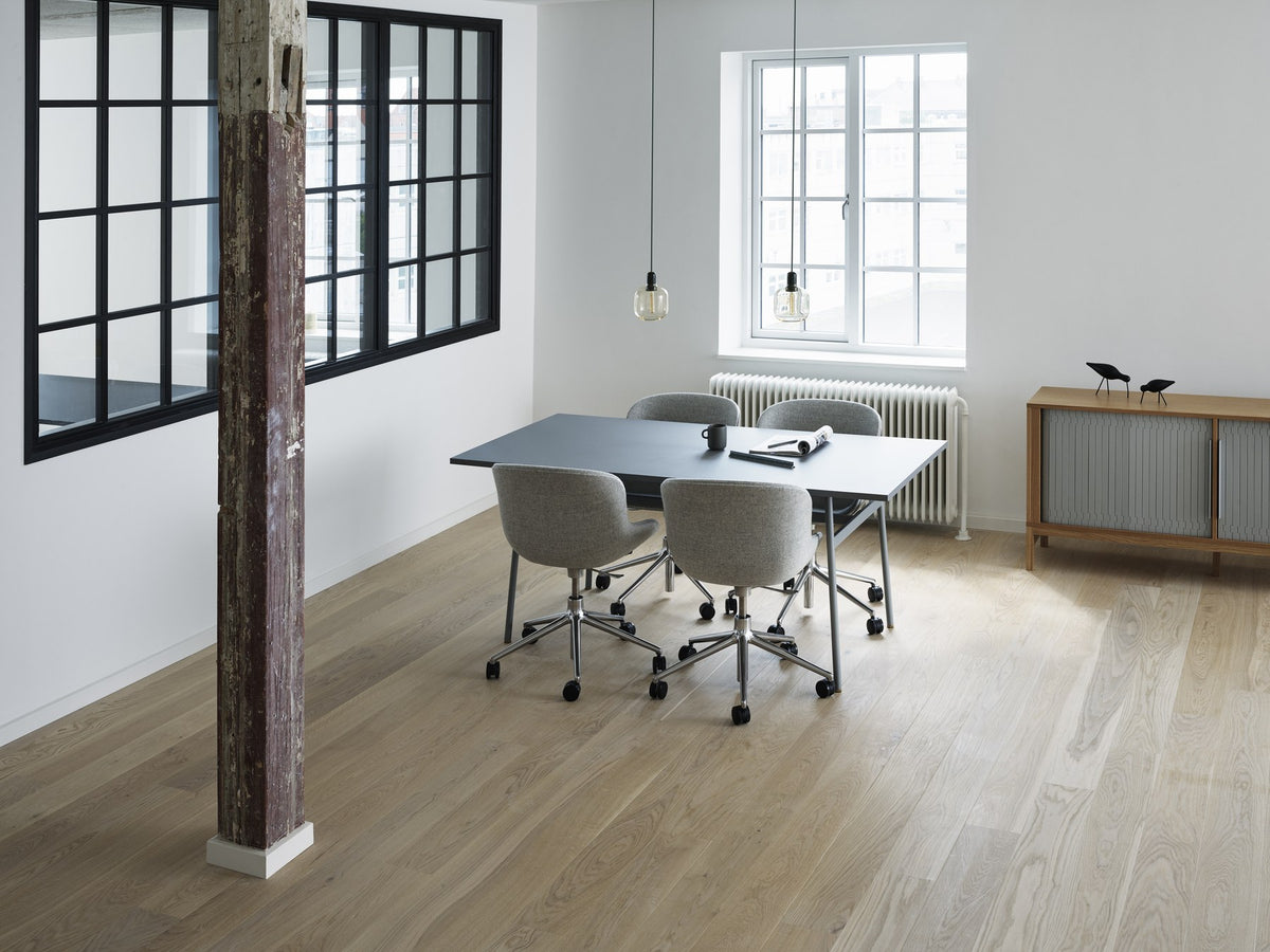 Grauer Hyg Comfort Drehsessel von Normann Copenhagen mit gepolsterter Schale, Aluminiumgestell und fünf Rollen auf drehbarem Fusskreuz.