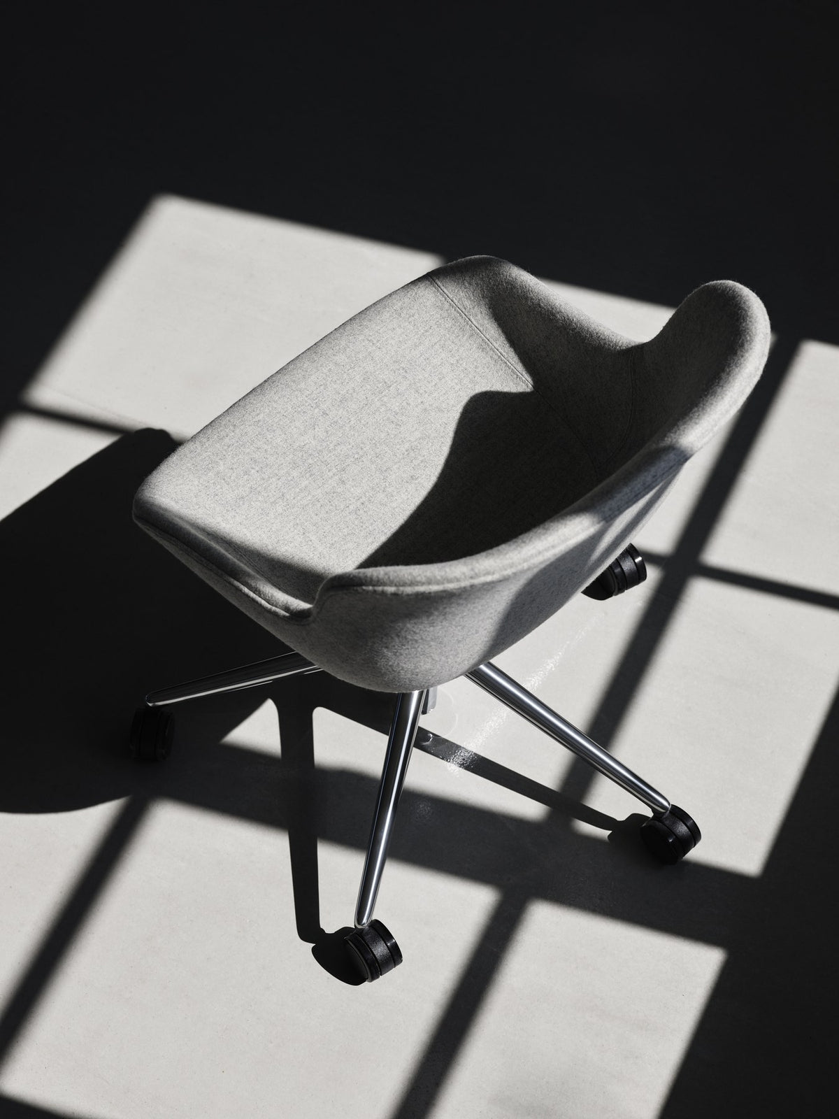 Grauer Hyg Comfort Drehsessel von Normann Copenhagen mit Polypropylen-Schale, Polsterung, Aluminium-Fussgestell und fünf Rollen.