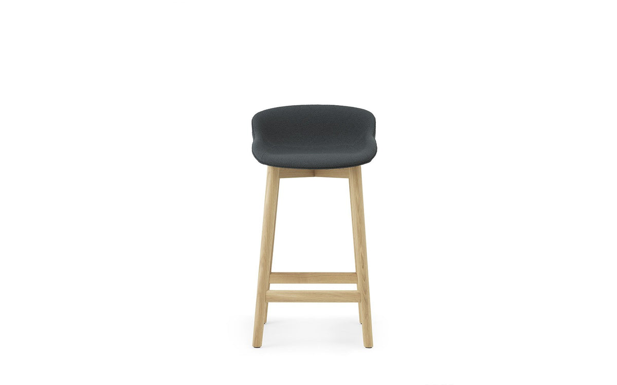 Hyg Barhocker von Normann Copenhagen, vollgepolstert, Sitzschale auf Beinen aus lackierter Eiche, Sitzhöhe 65 cm.
