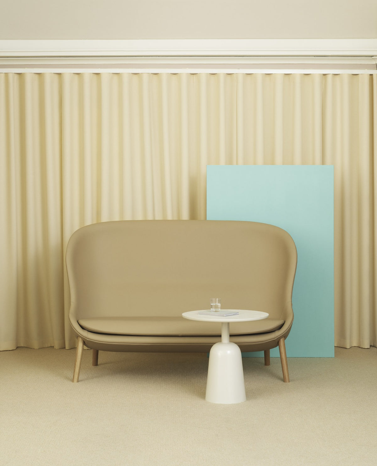 2er Sofa Hyg von Normann Copenhagen in Beige mit Eichenholzbeinen, geschwungene Form, hohe Seitenteile, geformter PU-Schaumkern.
