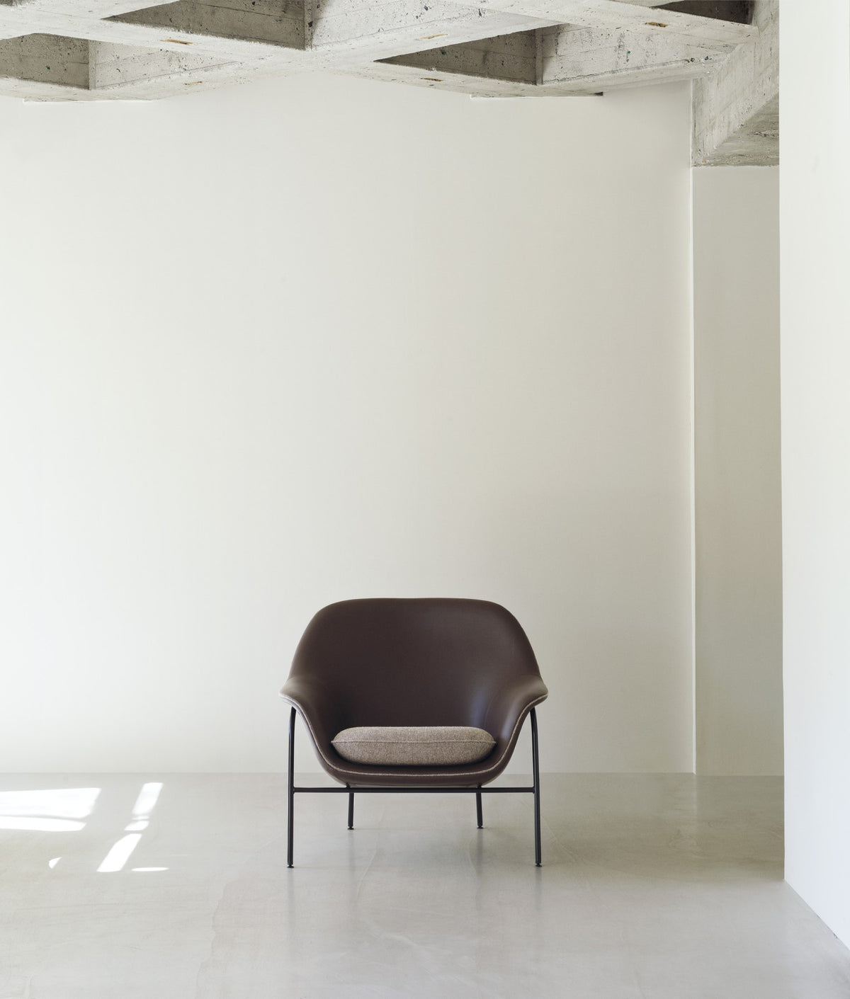 Drape Lounge-Sessel niedrig von Normann Copenhagen in Braun, Gestell aus pulverbeschichtetem Stahl, geschwungene Sitzschale mit Polsterung.