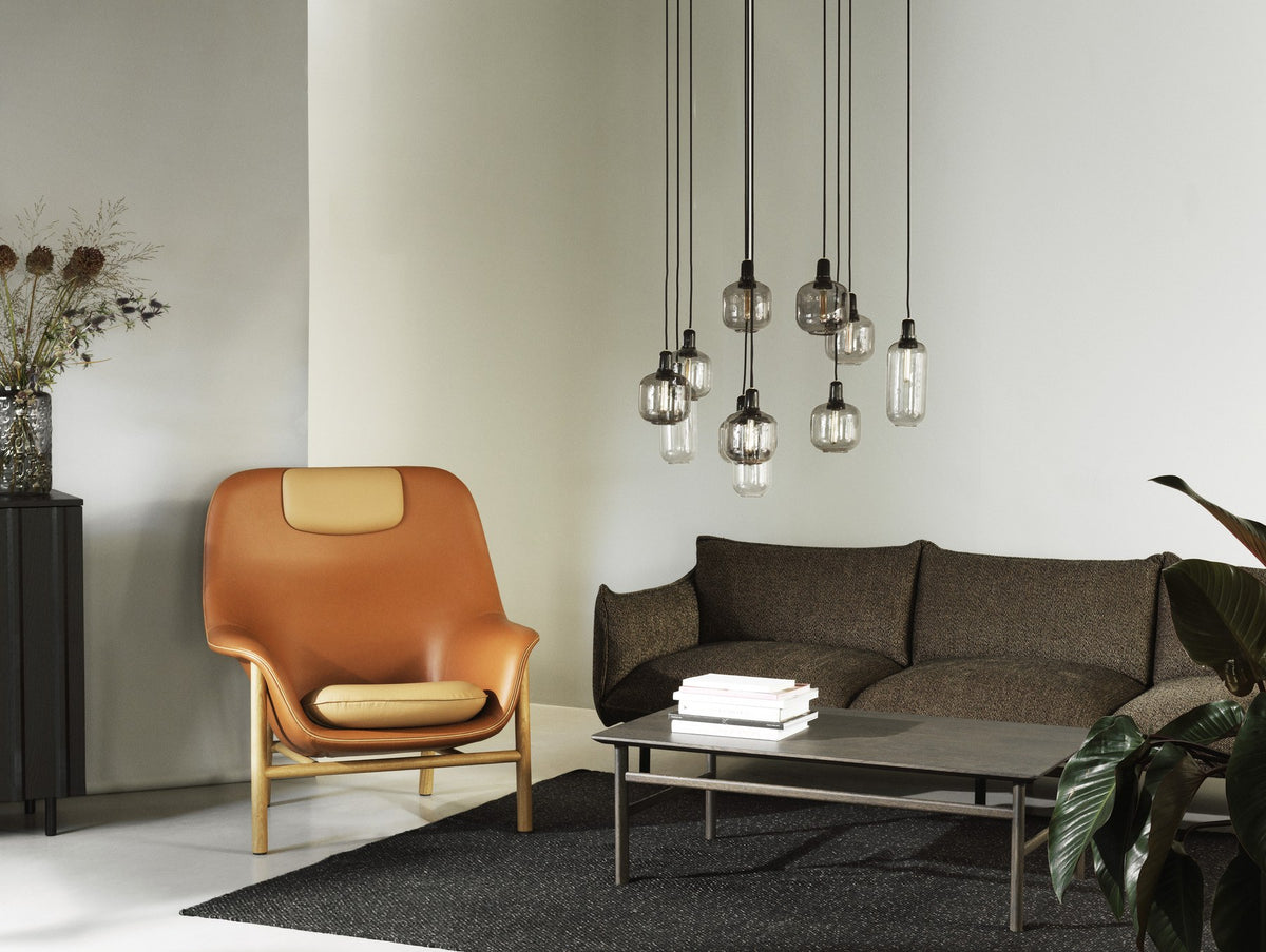 Drape Lounge-Sessel von Normann Copenhagen in Cognac mit hoher Rückenlehne, gepolsterter Sitzschale und Beinen aus Eichenholz.