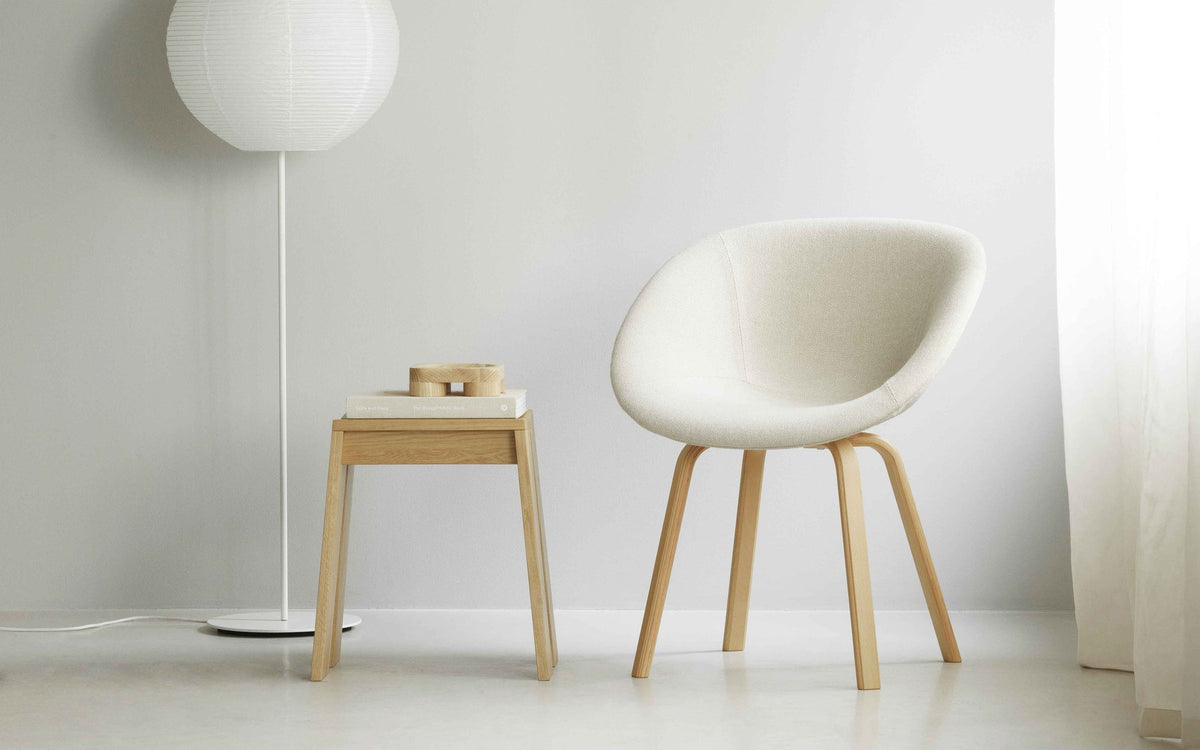 Mat Lehnstuhl mit Armlehne von Normann Copenhagen: Sitzschale aus Seegras-Hanf-Material, gepolstert in Beige, Gestell aus Buchenholz, runde Form.