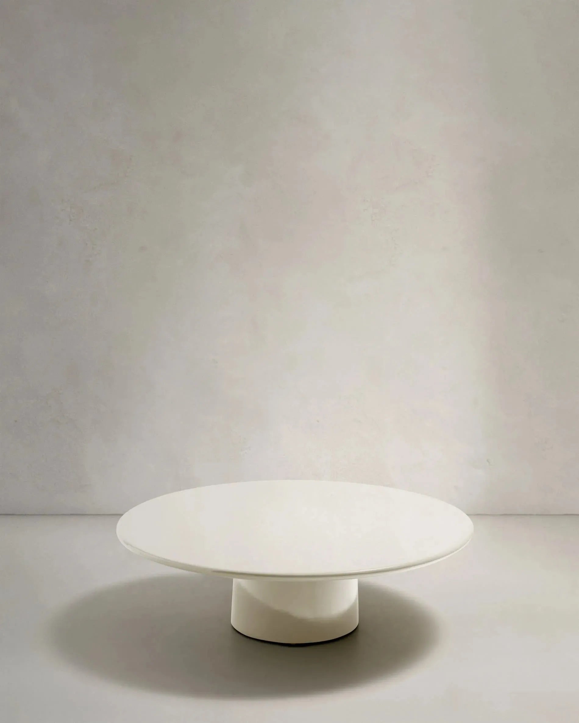 Eleganter Couchtisch aus wetterfestem Zement, Ø 110 cm, glänzend weiß, ideal für Terrasse und Garten.