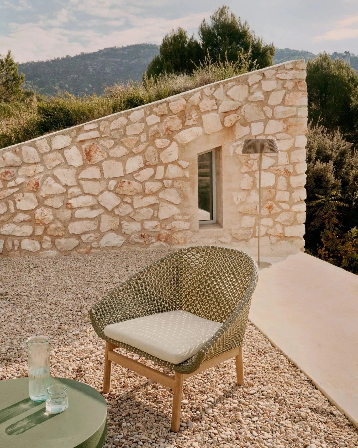 Moderner Sessel aus synthetischem Rattan und FSC-zertifiziertem Teakholz, ideal für stilvolle und nachhaltige Einrichtung.
