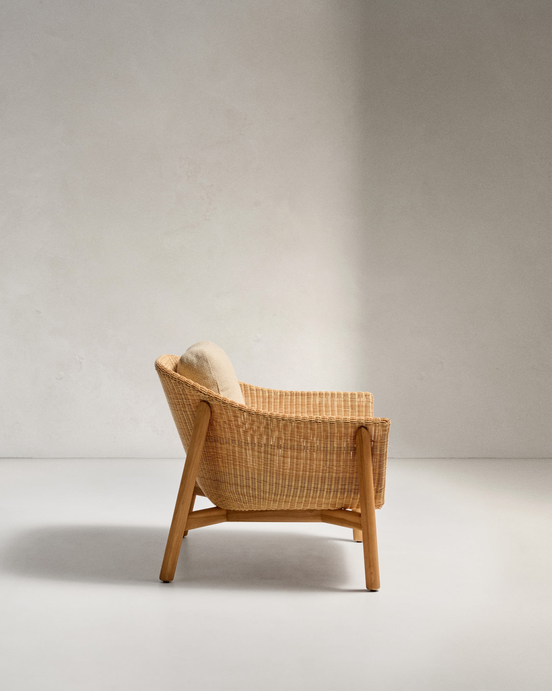 Eleganter Sessel aus Teakholz und synthetischem Rattan, ideal für stilvolle Entspannung im Freien.