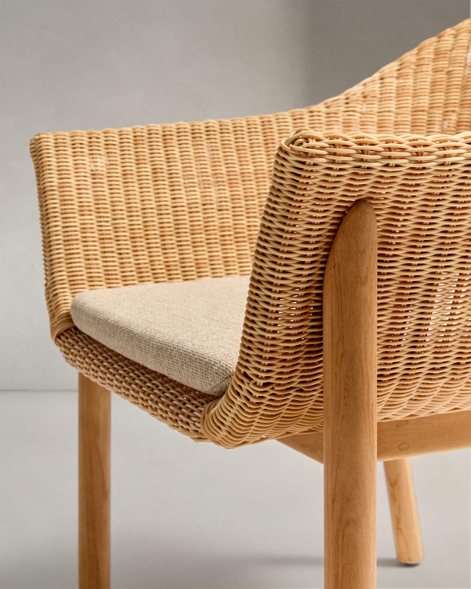 Der Galea Stuhl aus Teakholz und synthetischem Rattan vereint Nachhaltigkeit und Stil, ideal für modernes Wohnen.
