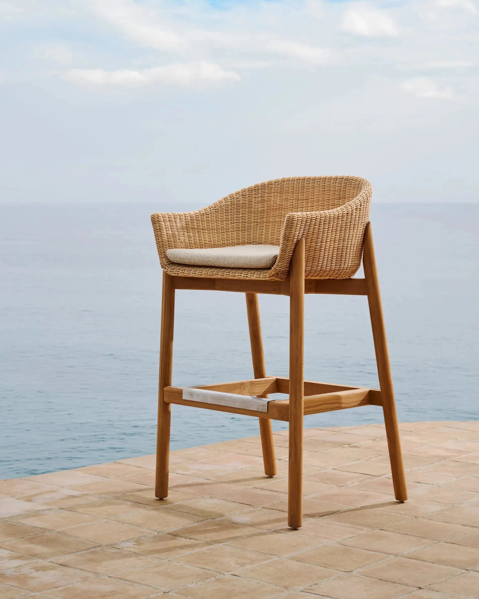 Eleganter Hocker Galea aus FSC-zertifiziertem Teakholz und synthetischem Rattan, 75 cm hoch, nachhaltig und modern von Kave Home.