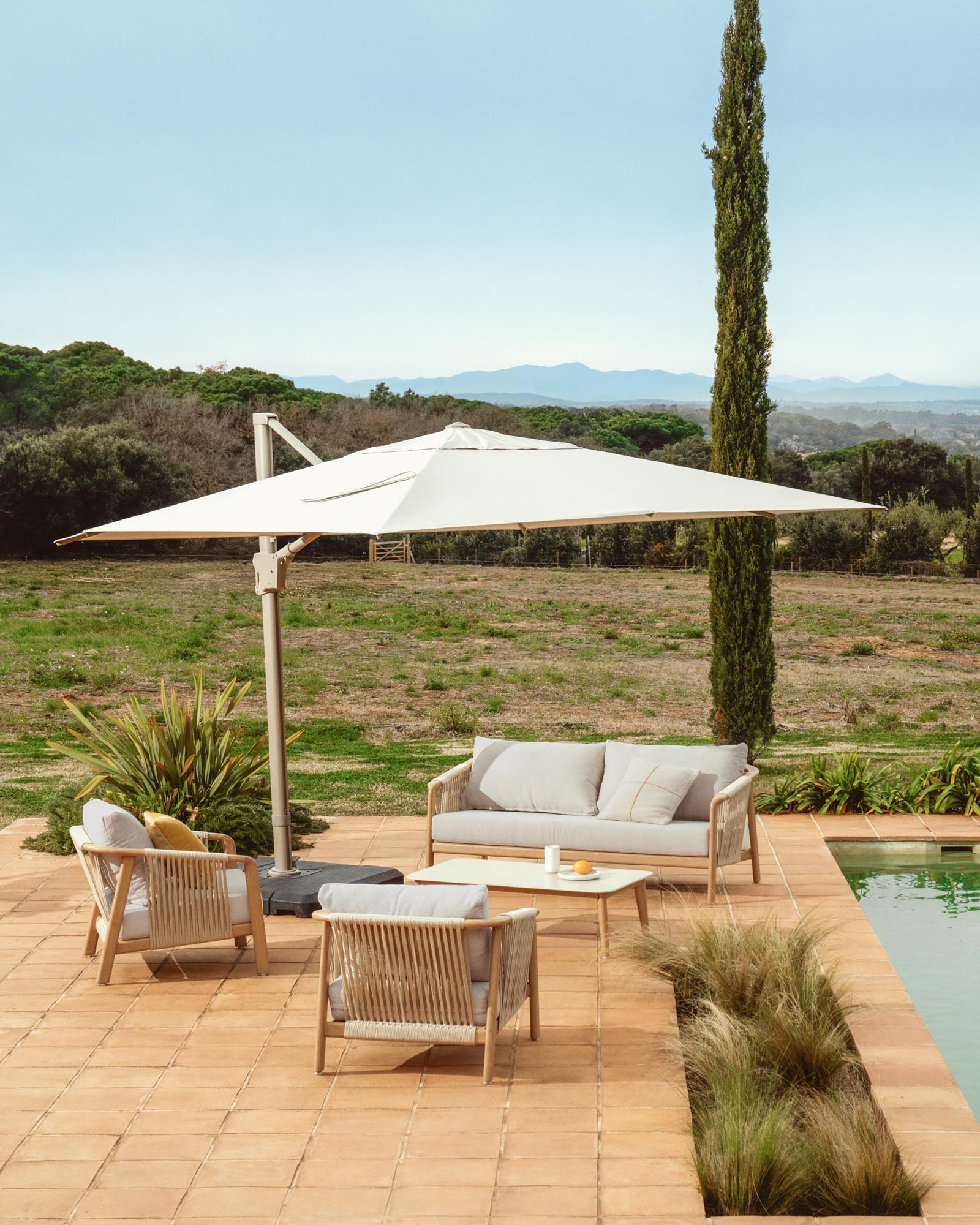 Eleganter, exzentrischer Sonnenschirm Noli in sanftem Beige, mit robustem taupefarbenem Aluminiumgestell, ideal für stilvolle Outdoor-Bereiche.