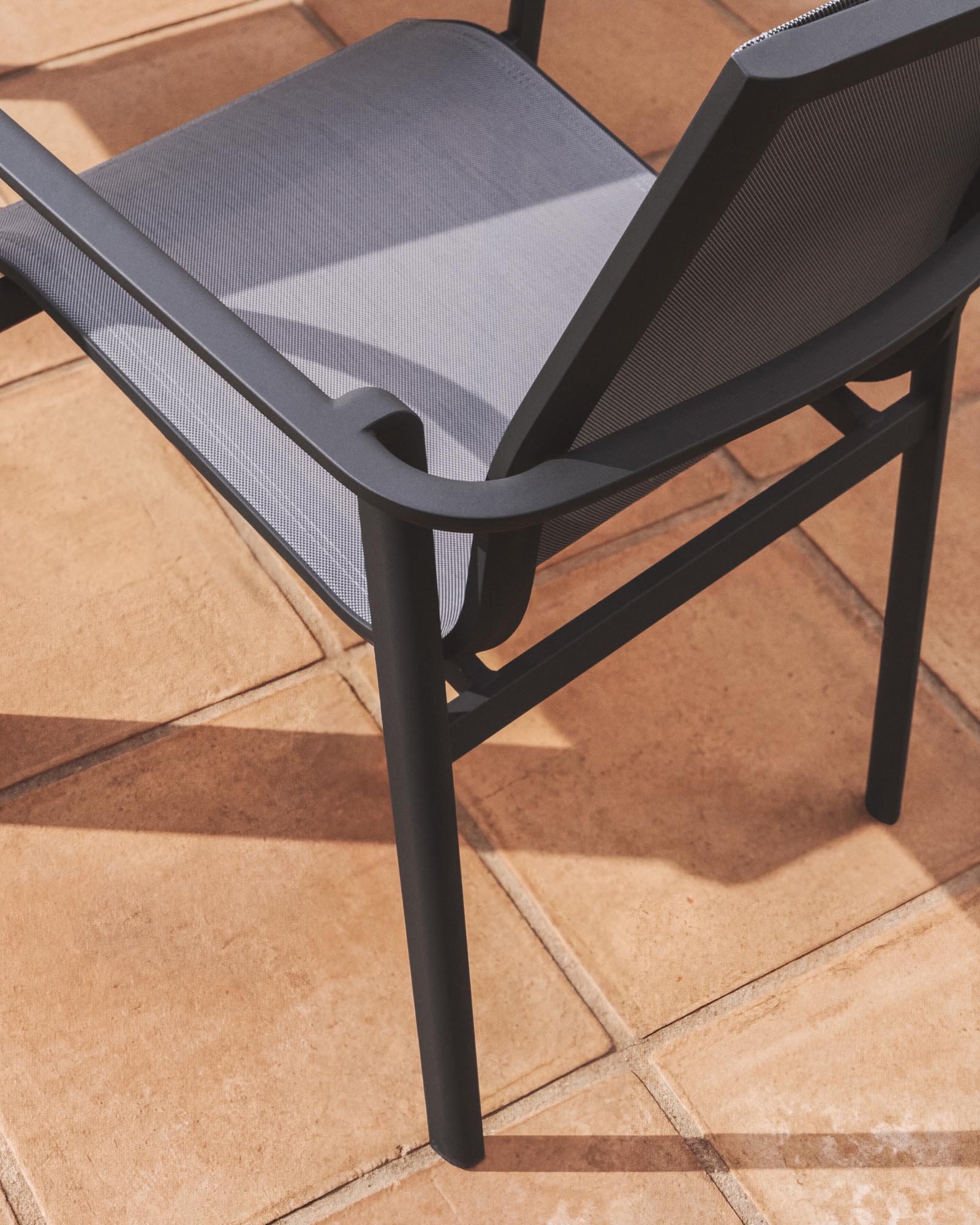 Stapelbarer Outdoor-Stuhl Canea aus grauem Texteline und Aluminium in Graphit in Graphit präsentiert im Onlineshop von KAQTU Design AG. Gartenstuhl mit Armlehnen ist von Kave Home