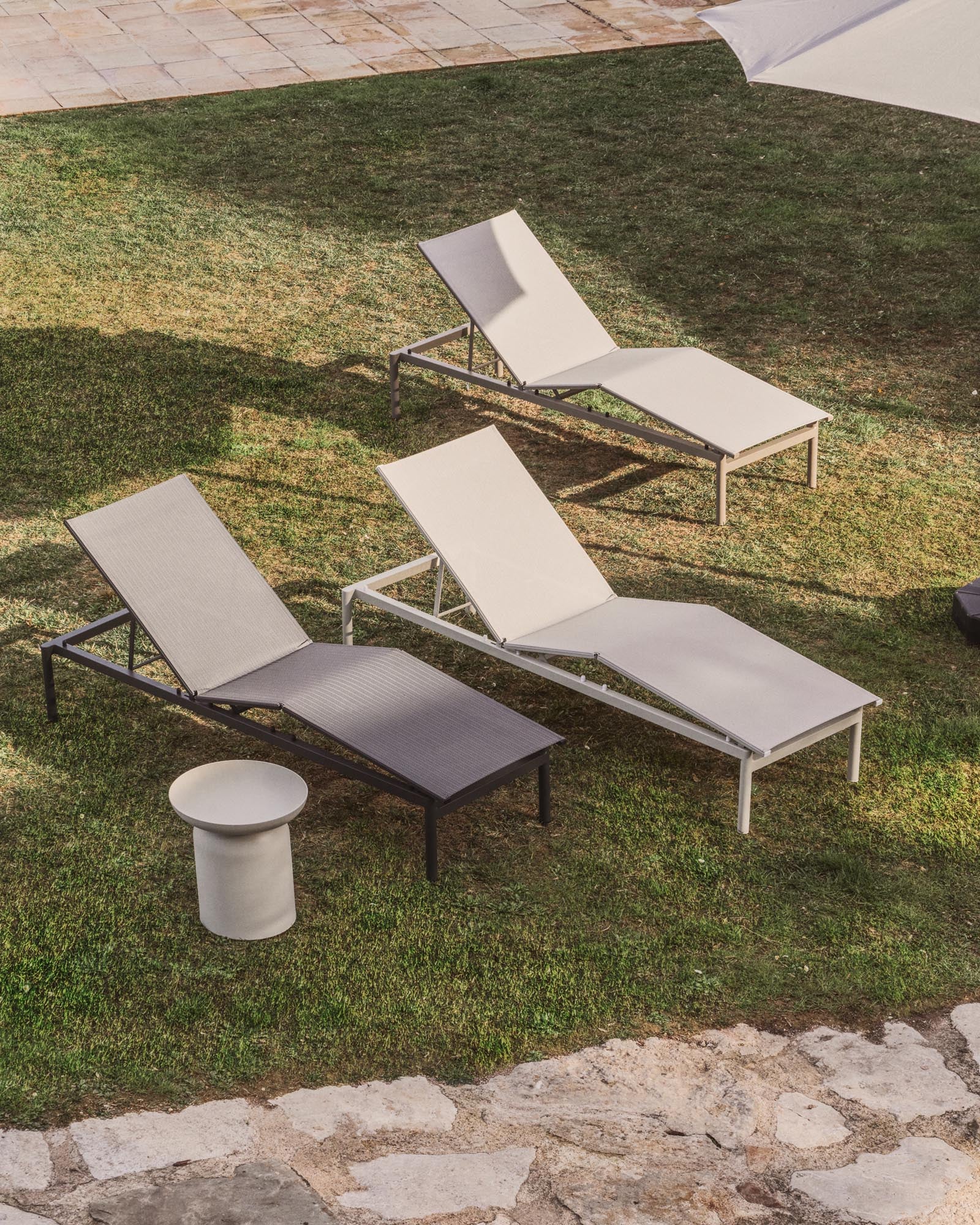 Stapelbare Sonnenliege Lesina aus taupefarbenem Aluminium und ecrufarbenem Texteline, perfekt für stilvolle Entspannung im Garten oder auf der Terrasse.