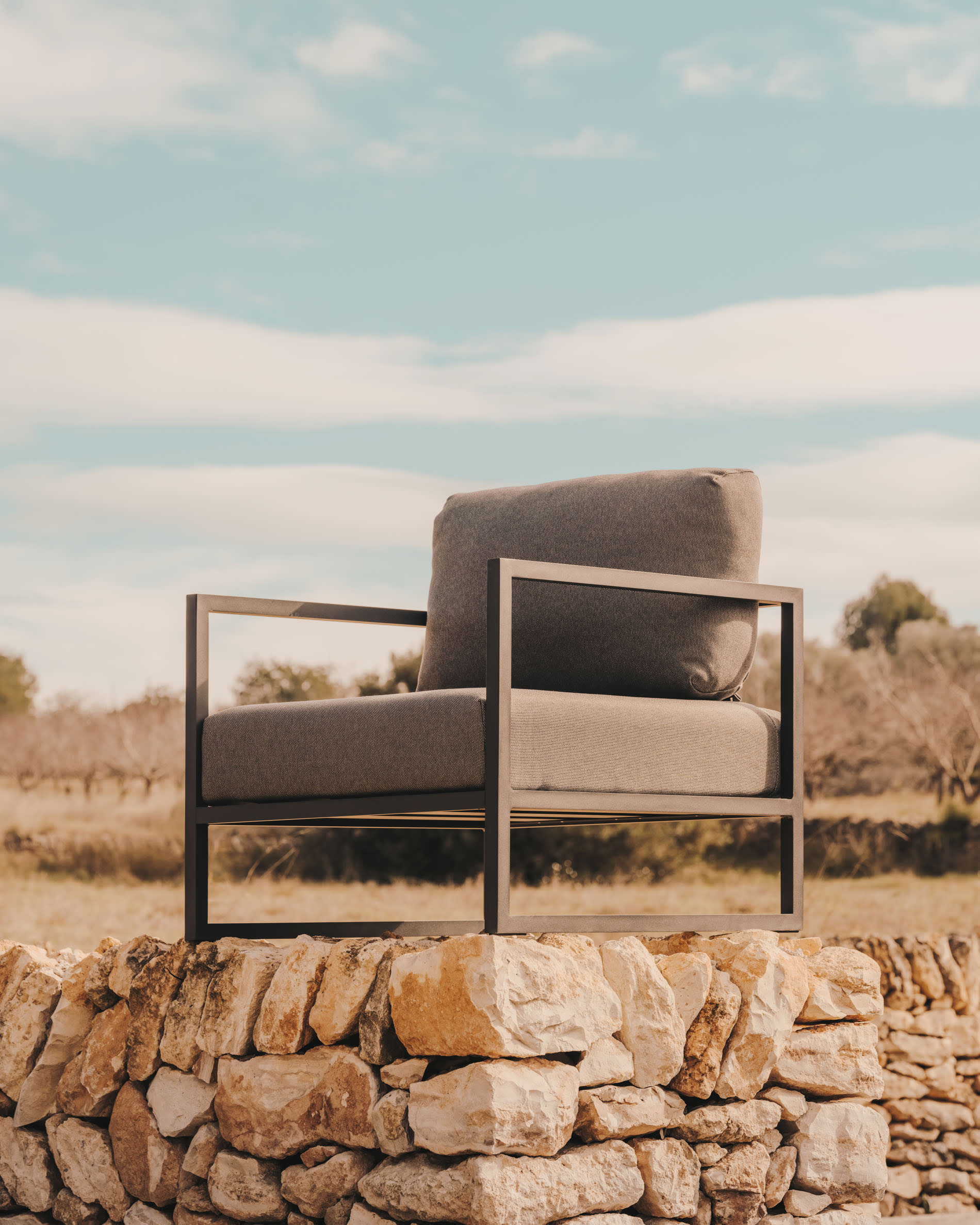Moderner Comova Outdoor-Sessel aus robustem Aluminium in Schwarz und dunkelgrauem Stoff, ideal für stilvolle Außenbereiche.