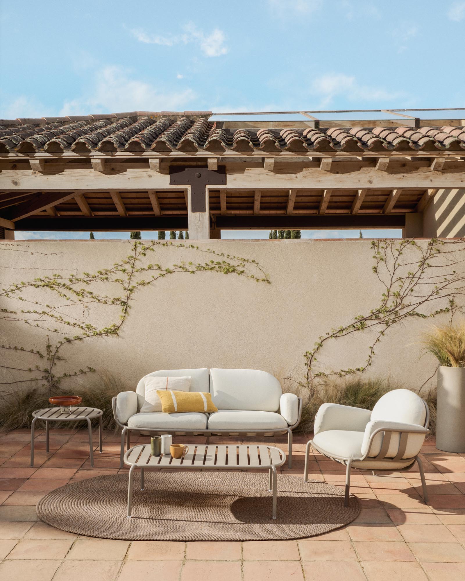 Stylisches 2-Sitzer-Outdoor-Sofa Joncols in taupe mit beigen Kissen, ideal für entspannte Stunden im Freien.