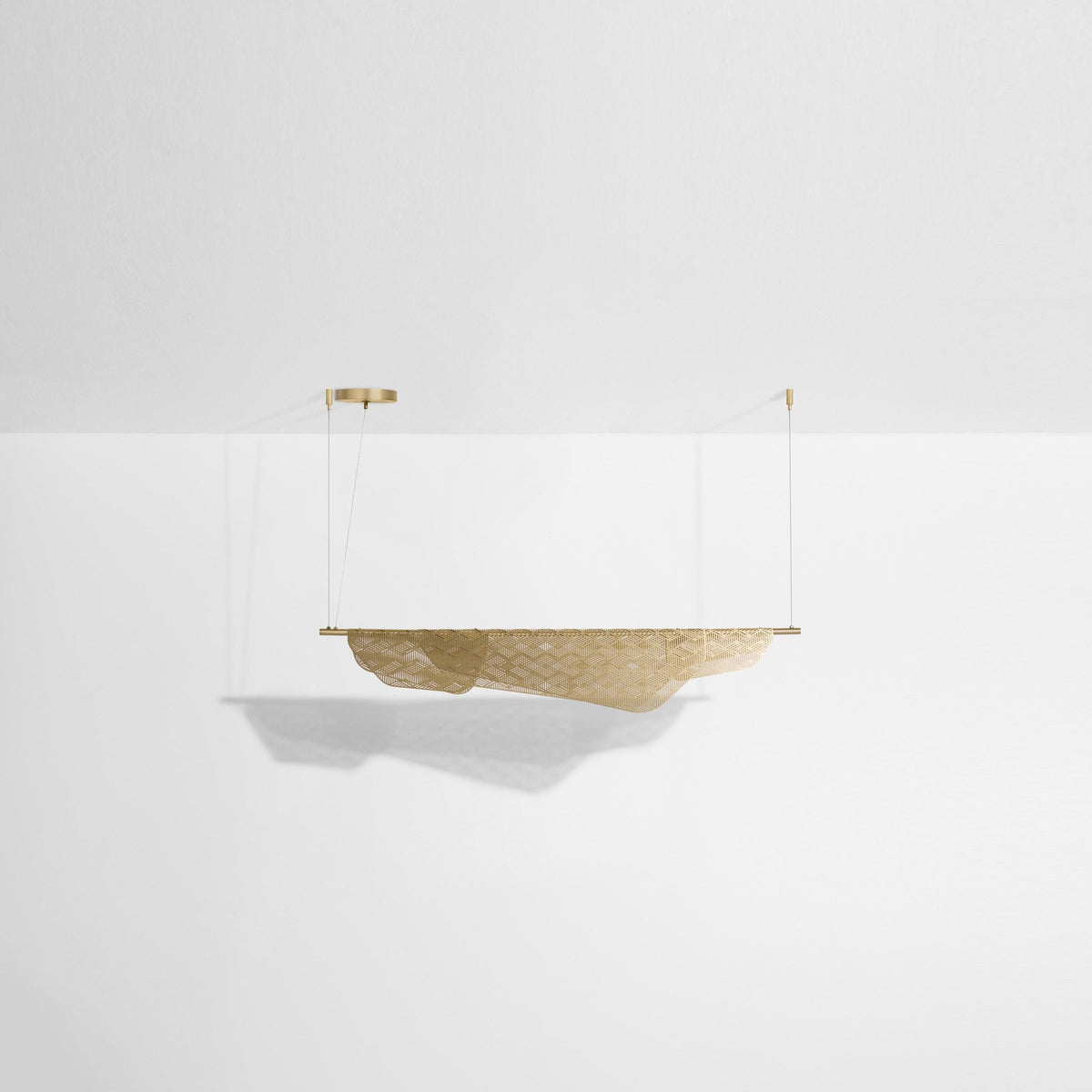 Pendelleuchte Mediterranea aus gebürstetem Messing mit filigraner, durchbrochener Struktur und geometrischem Schattenmuster.