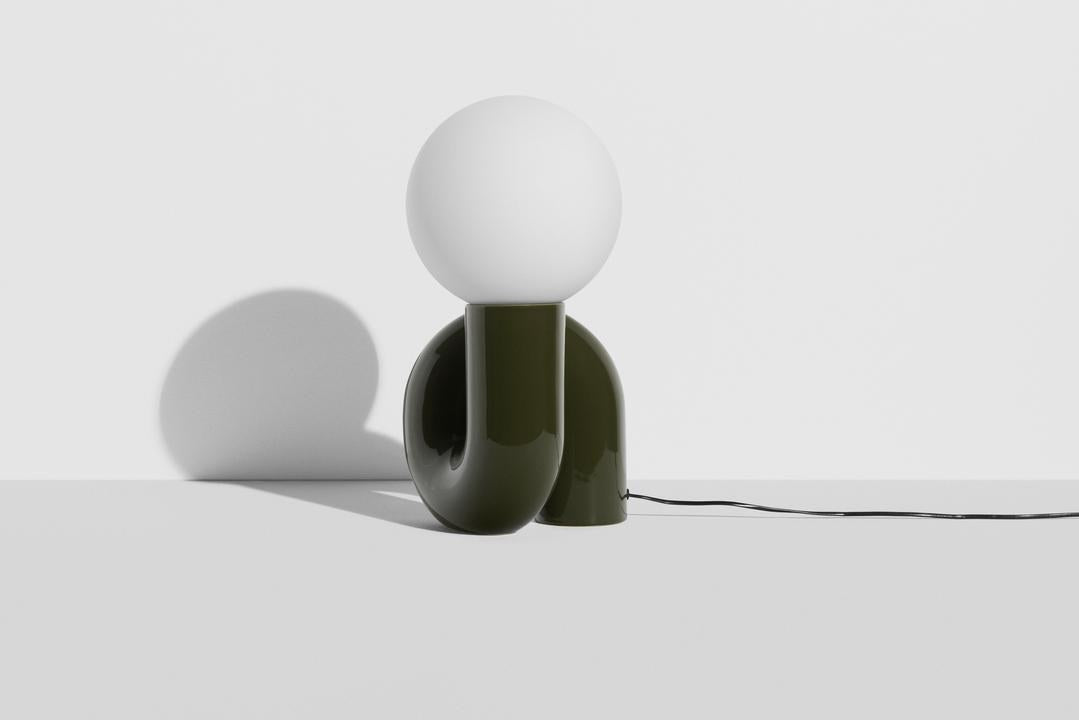 Grosse Tischlampe Neotenic von Petite Friture mit glänzend kirschrot glasiertem Keramiksockel und sandgestrahltem weissem Glasglobus in geschwungener Form.